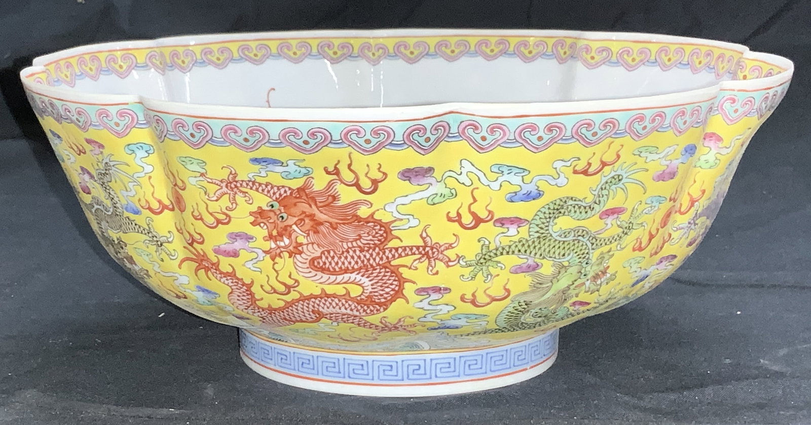 Hand Painted Eggshell Porcelain Chinese Bowl: Dragon motif Chinese eggshell porcelain bowl. Translucent porcelain bowl with wide scalloped rim. Multi chrome dragons on a yellow background. . Interior is white with a center medallion of a Chinese 