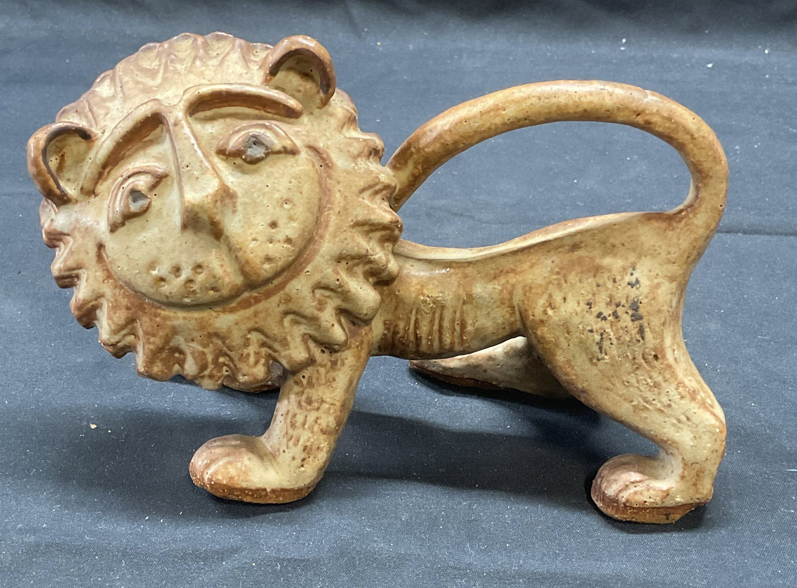 Vintage Stoneware Lion Figural: Vintage glazed stoneware Lion figural. Hues of beige and brown. Measures approx. 7 x 3.5 x 4.25 inches. Some surface wear including scratching observed. Previously repaired. Lion, stoneware lion, lion