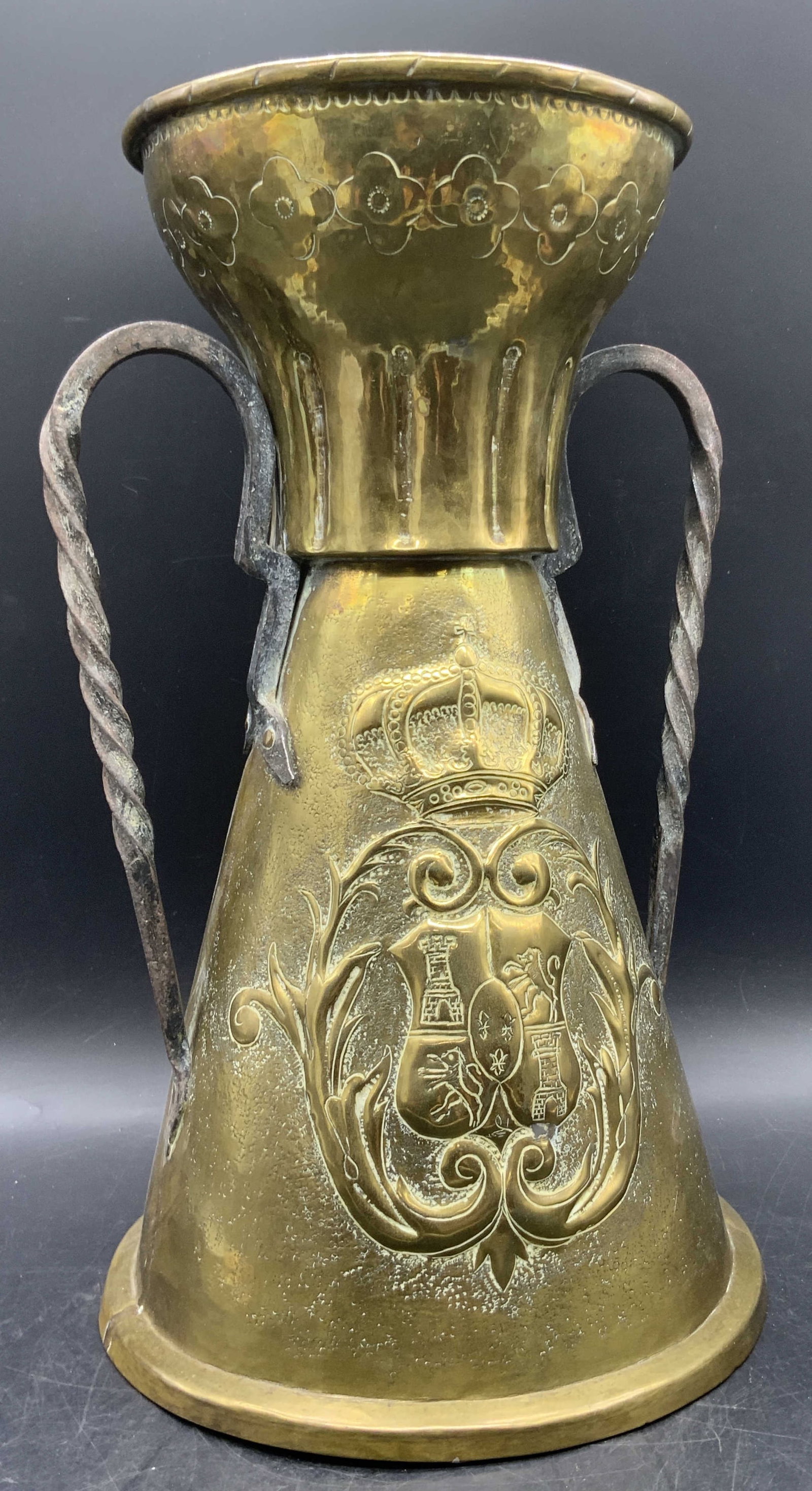 Vintage Brass Repousse Vessel, 14.5 Inch Height: A vintage brass, possibly brass plated, repousse vessel featuring twin handles to either side. The applied handles are crafted from metal, appears to be iron. Crest and crown motif to the center of th