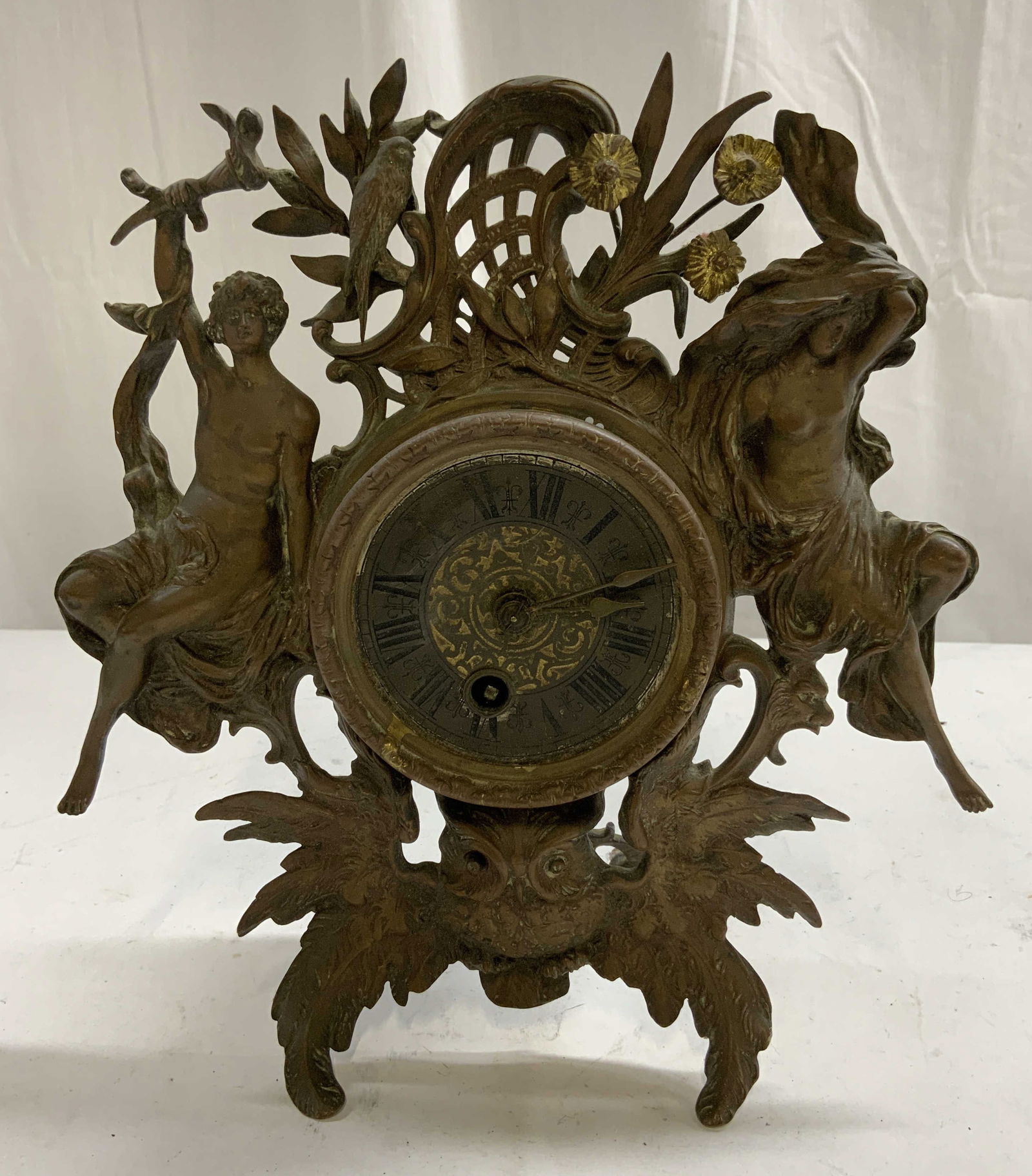 Antq French Gilt Metal Mantel Clock: Mantel clock is antique. Piece is gilt metal, appears to be bronze possibly brass. Piece has partially nude male and female figure. Clock also has owl, bird, floral, scroll and leaf detail. Clock has