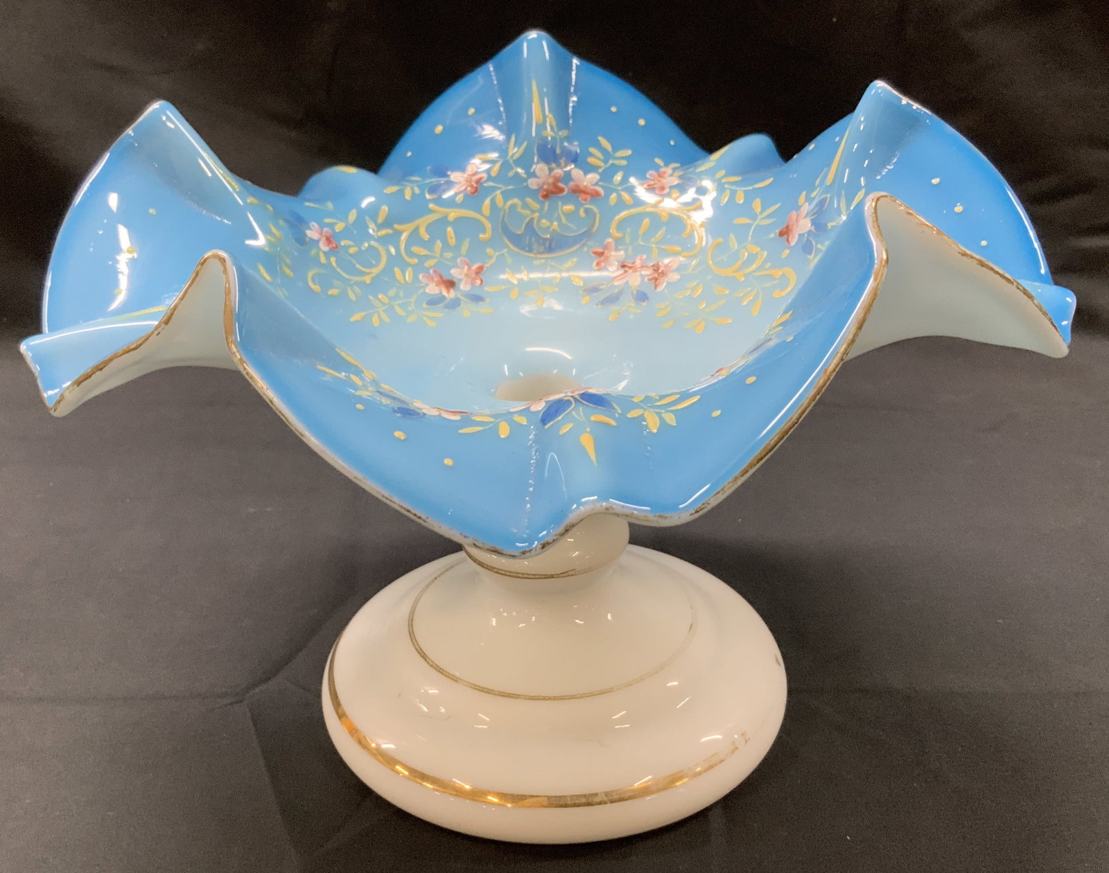 Mid Cent Painted Blown Milk Glass Tazza: Handkerchief Mid century hand blown milk glass Tazza. Hand painted blue with flowers on the top. Some loss of gilt on base. Measures 9.5 in. Diameter x 6.75 in. Ht. Mid century hand blown milk glass T