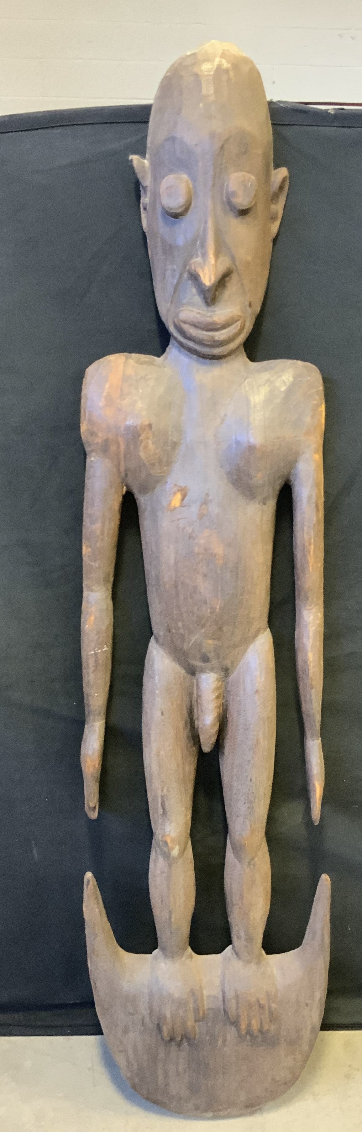 Hand Carved Nude Male Figure Wall Hanging, 64 In Ht: A vintage hand carved nude male figure wall hanging crafted from wood. Metal hardware to reverse for hanging. Measures approx. 64H x 14W in. Chipping, losses to wood, discoloration and surface wear pr