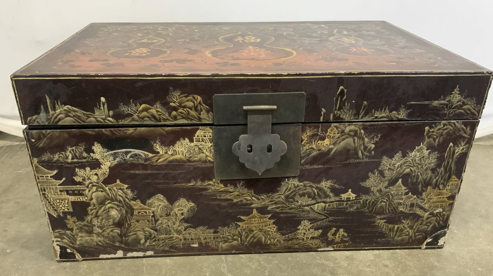 Vintage Asian Chest With Lid: Chest is vintage. Piece is crafted from a lightweight board material. Chest has hinged lid. Piece has intricate landscape detail with Asian architecture. Piece has gilt metal locking mechanism. Interi