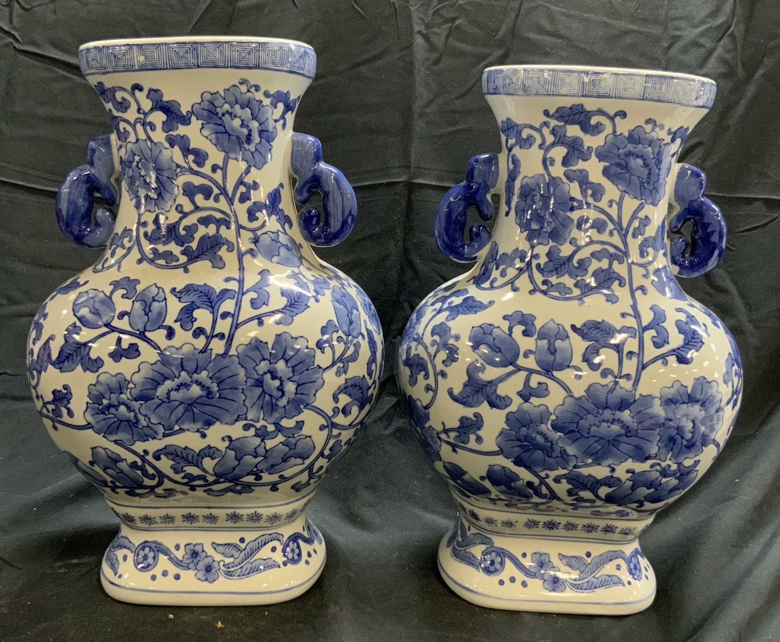 THE BOMBAY COMPANY Pr Asian Porc Chinoiserie Vases: Tag reads THE BOMBAY COMPANY. Lot includes 2 vases. Each are white with blue toned floral, vine and leaf detail. Vases each have blue toned handles at neck. Asian Porcelain Chinoiserie vases. Each mea
