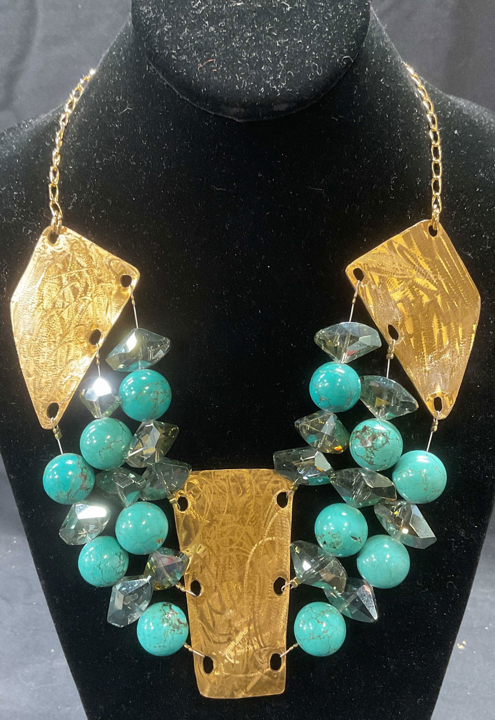 Gold Tone Turquoise & Crystal Beaded Necklace: Gold tone necklace with panel pendants and three strands of turquoise and glass crystal beads. Drop length approx. 9 inches. Necklace has weight. Some surface wear including scratching observed. Jewel
