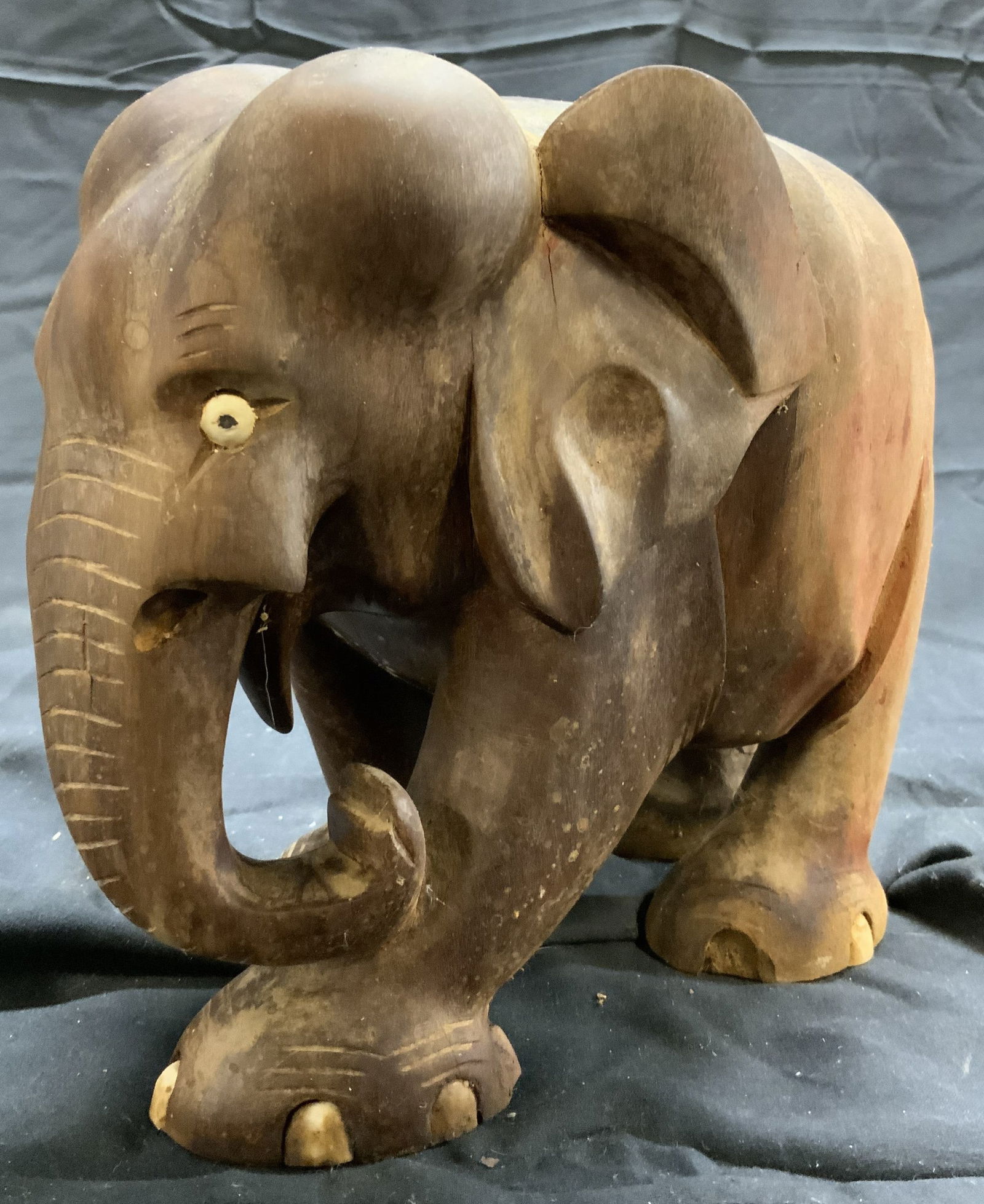 Hand Carved Wooden Elephant Figural: Elephant figure is wooden. Piece is brown toned and appears to be hand carved. Some areas such as eyes and toe areas have bone detail. Piece measures approximately 7 inches tall 8.5 inches deep 5 inch