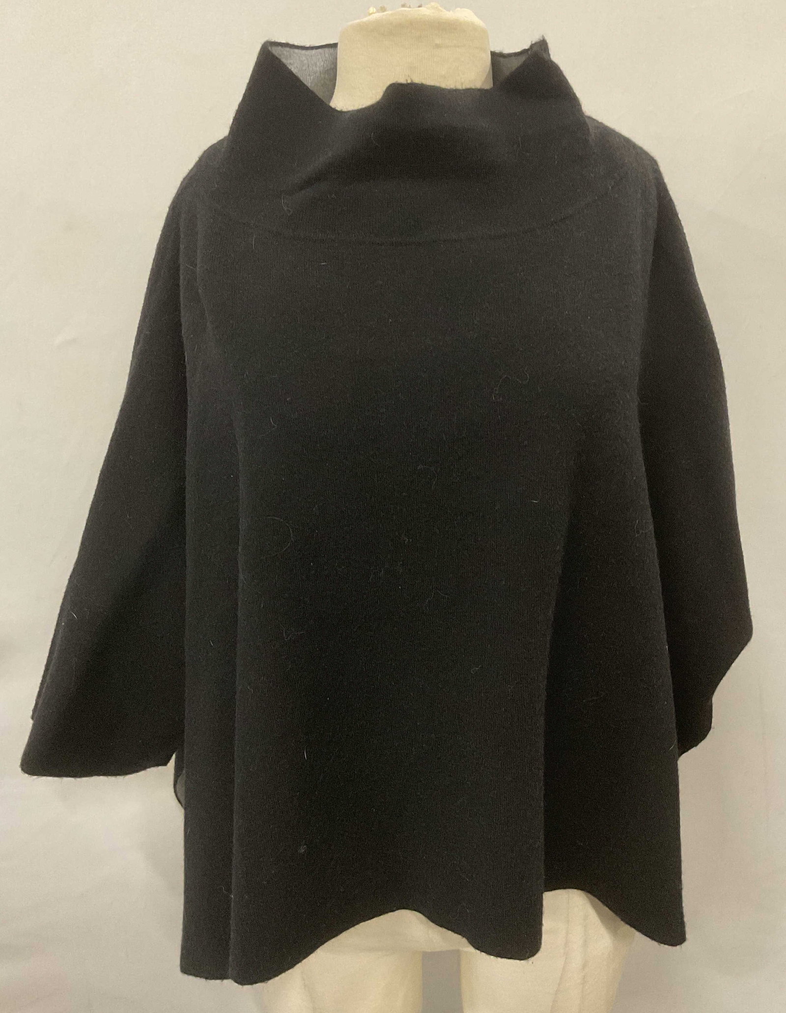 Subdued Black Dolman Sleeve Sweater: Subdued black dolman sleeve sweater. Funnel mock neck. Open seam on sides. One size. Measures approx. 33 inches across chest. Material feels synthetic. Some wear to material consistent with exposure. 