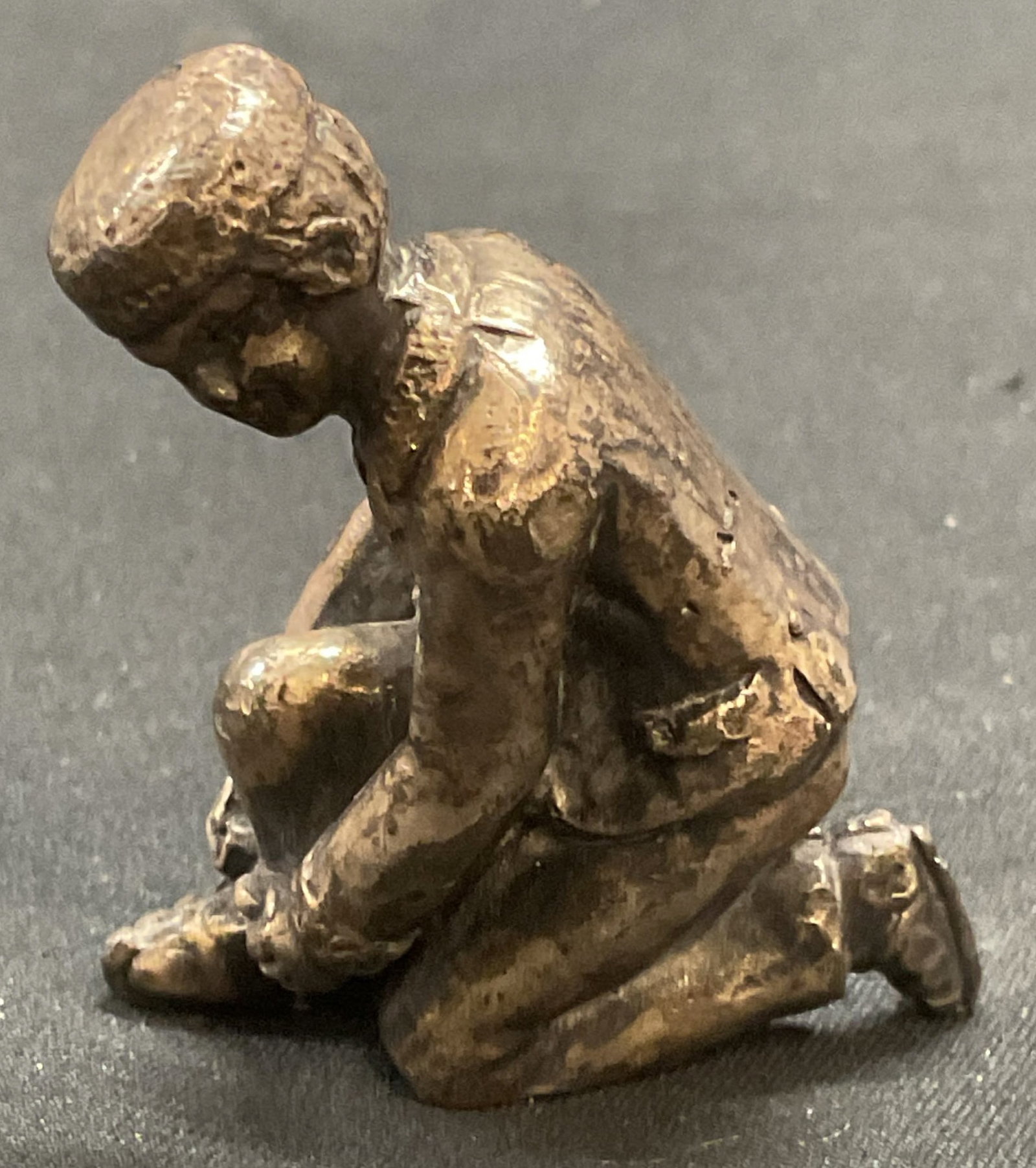 Silver Tone Shoe Tying Motif Figural: Silver tone figural. Man tying shoe motif. Piece has weight. Measures approx. 1.5 x .75 x 1.75 inches. Some surface wear including patina observed. Silver tone figural, shoe tying figural, man figural