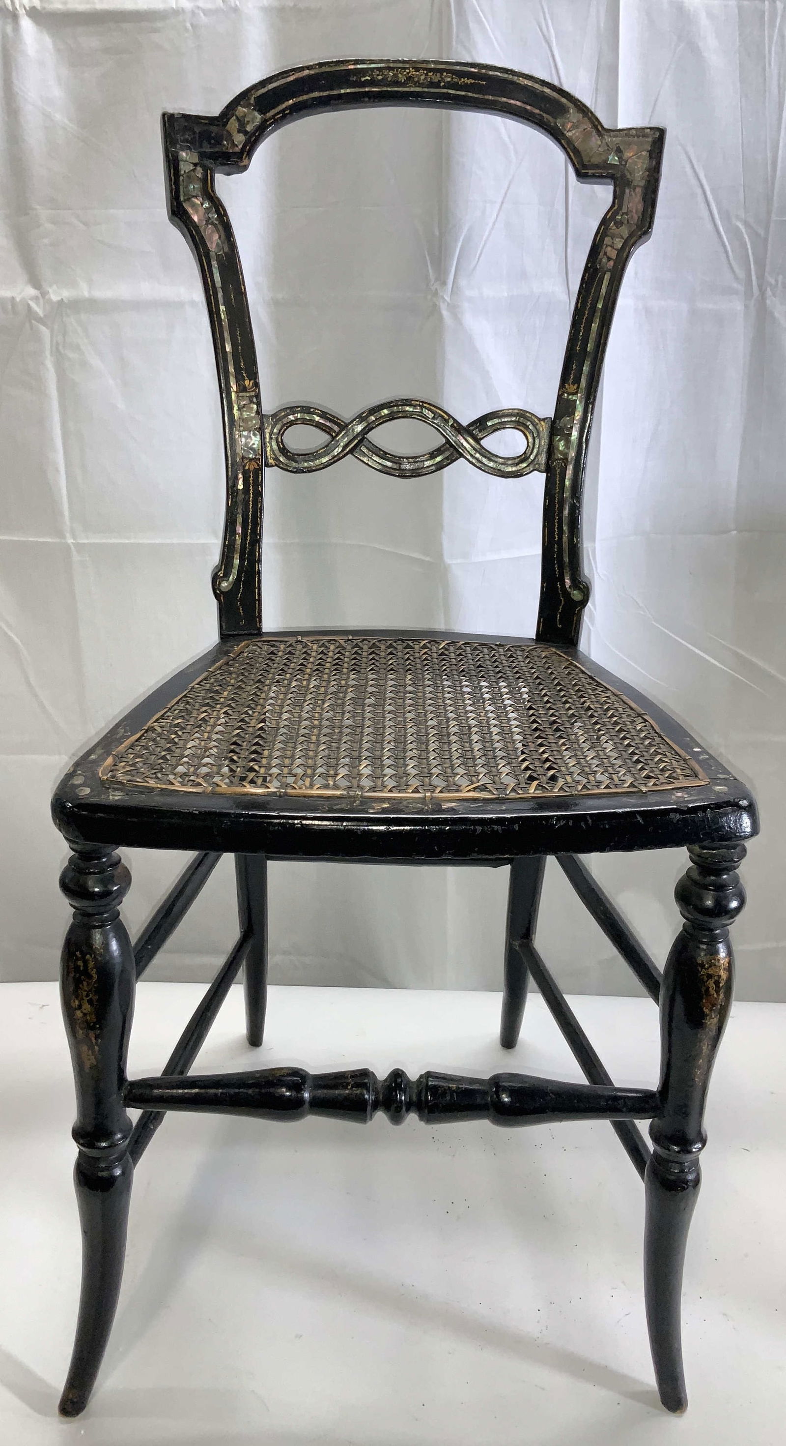 Antq Inlaid Mother of Pearl Bergere Wood Chair: Hand painted black lacquered wood chair with inlaid mother of Pearl/ abalone on back, accented with gold paint and cane work seat. Spindle wood front legs. Possibly late 19 th century. Has wear. Light