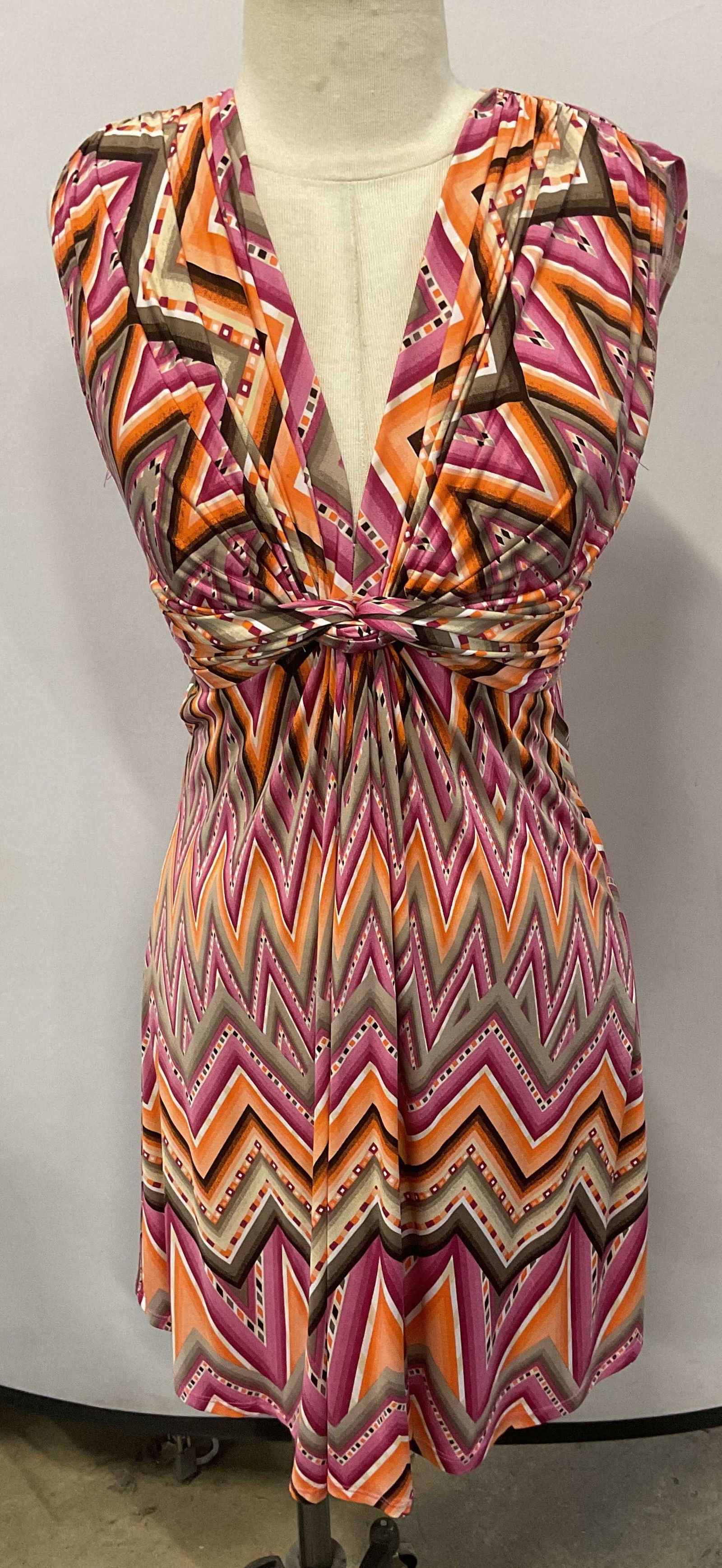 Pink & Orange Stripe Sleeveless Dress, France: Pink and orange zigzag stripe pattern sleeveless dress with knot and tie waist detail. Measures approx. 15 inches across chest, 36 inches from shoulder to hem. Synthetic material, fabric is very stret