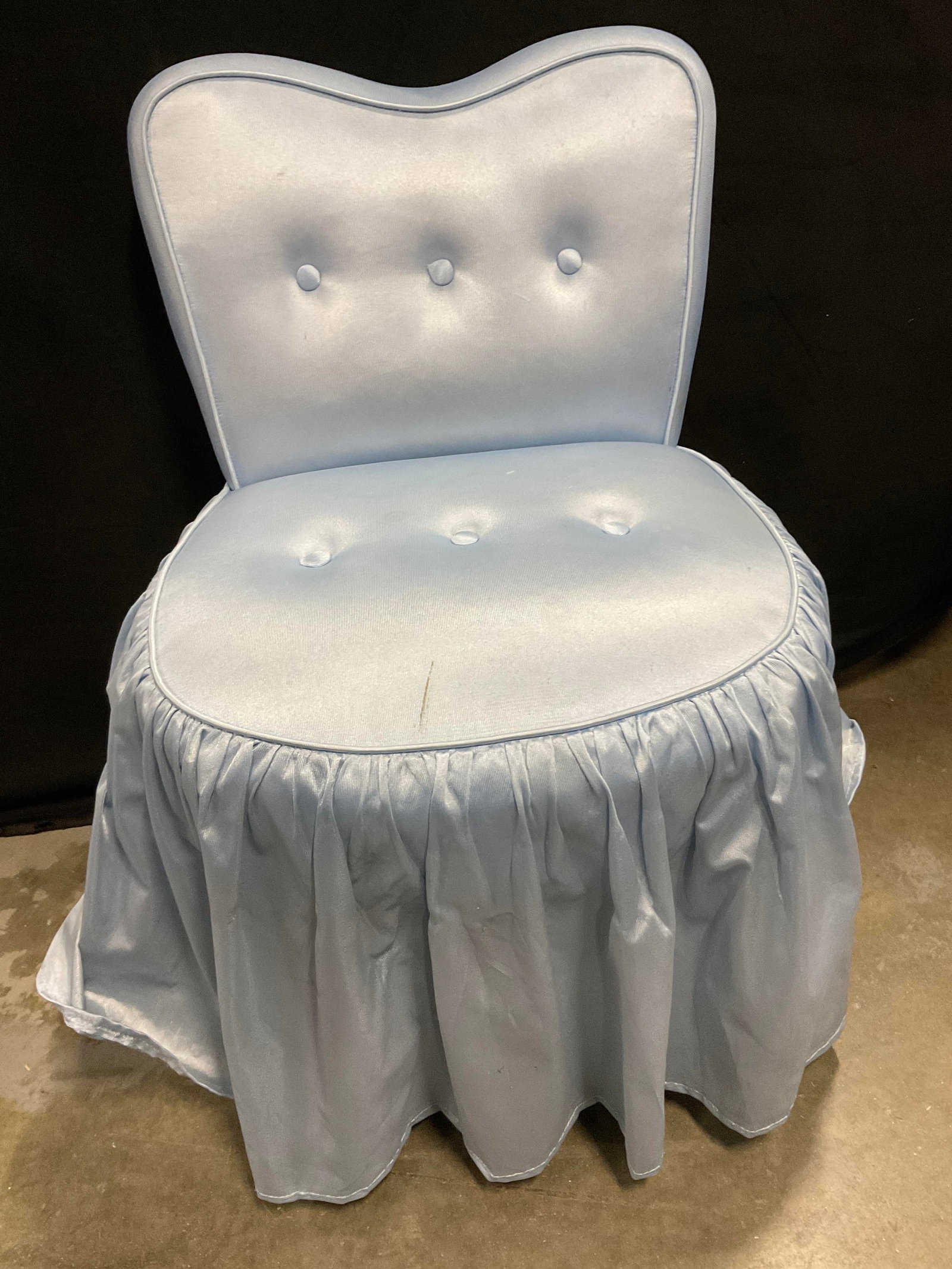 CHICAGO FURNITURE MFG Blue Skirted Vanity Chair: A vintage blue soft hand upholstery skirted vanity chair. Tufted seat and back. Tag to underside reads CHICAGO FURNITURE MFG. Measures approx. 20.5W x 30H x 18D in. Discoloration, tearing, and surface