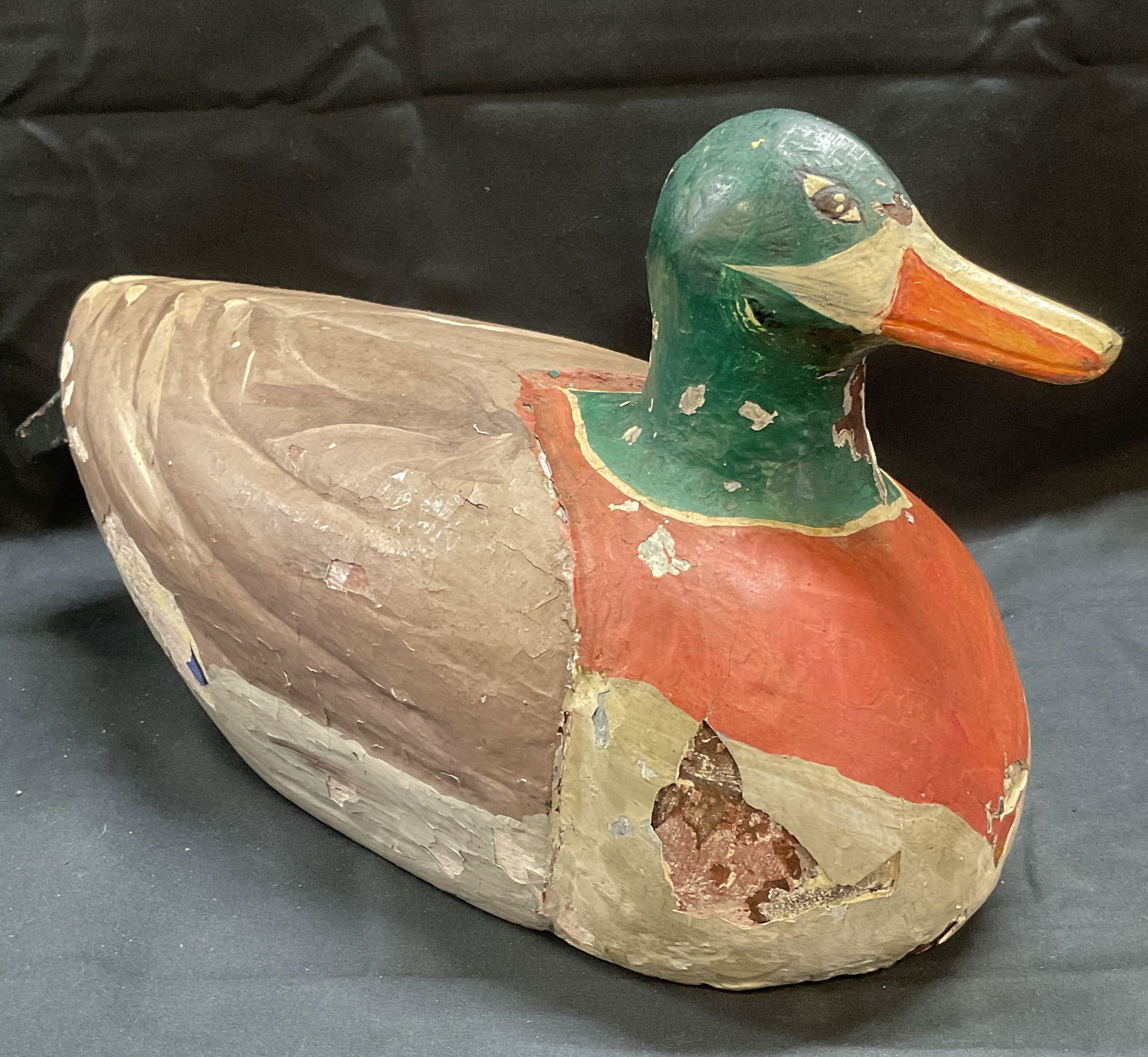 Vintage Hand Painted Wood Decoy Duck Figural: Vintage hand wood and plaster covered decor duck figural. Hand painted in green, red, and grey. Measures approx. 13 x 5 x 8 inches. Surface wear including chipping and loss to surface observed. Decoy
