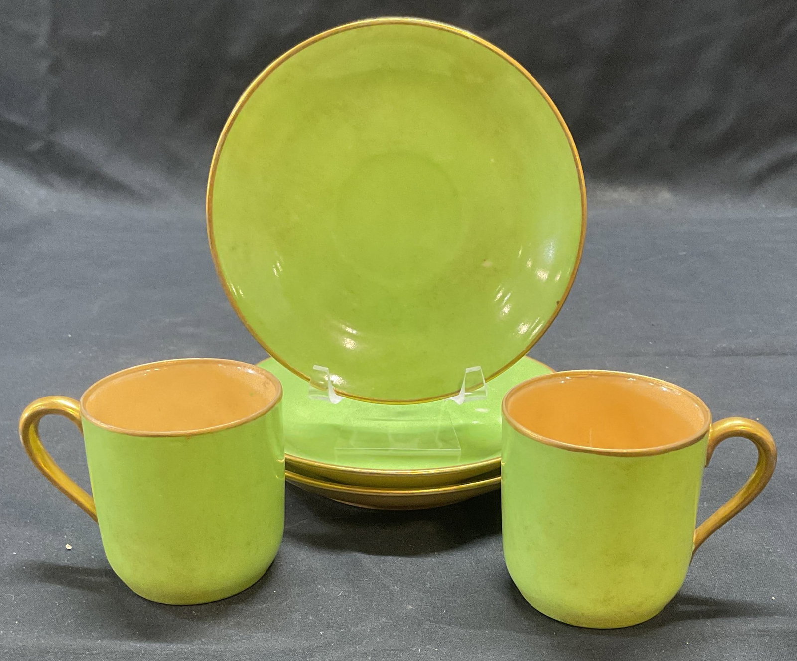 Set 5 Gilt Green Porcelain Demitasse & Saucers: Set of 5 pieces of gilt green porcelain demitasse cups and saucers. Cups measure approx. 2 x 2 inches. Saucers measure approx. 4.5 inches diameter. All pieces have surface wear including scratching an
