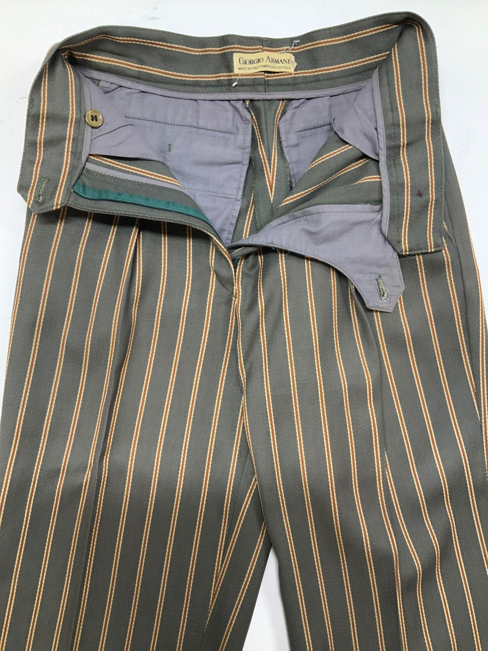 Giorgio Armani Rolled Capri Trousers, Italy: Giorgio Armani Striped Capri Trousers with rolled hems. Made in Italy. Pleated at waist, hand and back pockets. 26.5 in. Long. Inseam is 15.25 in. Waist is 24/25 in. . Mocha with brown stripes. Needs