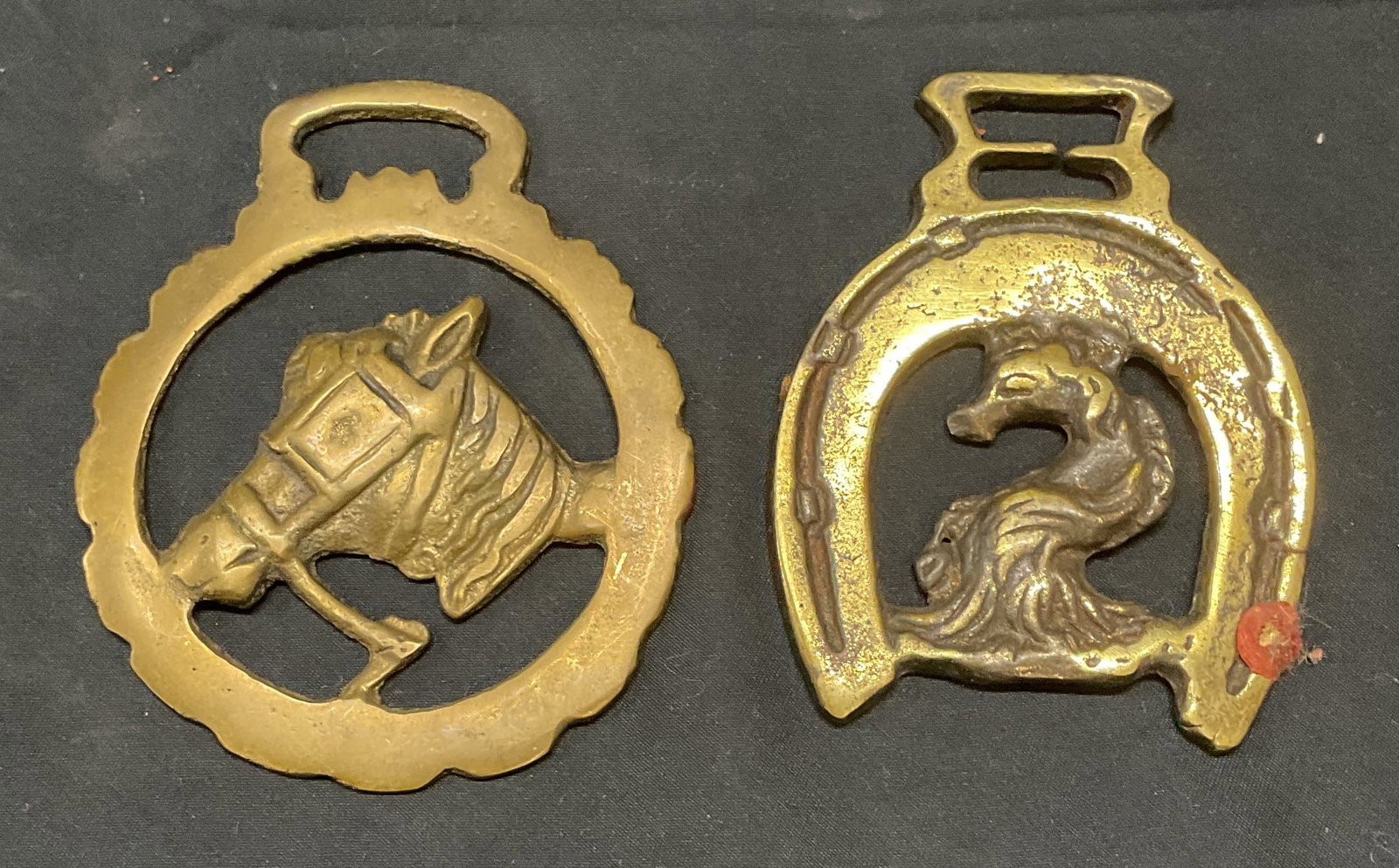 Lot 2 Vintage Brass Horse Medallions: Lot of 2 vintage brass horse medallions. Larger piece measures approval 3.75 inches long. Both pieces have surface wear including scratching observed. Horse medallion, brass horse medallion, vintage h