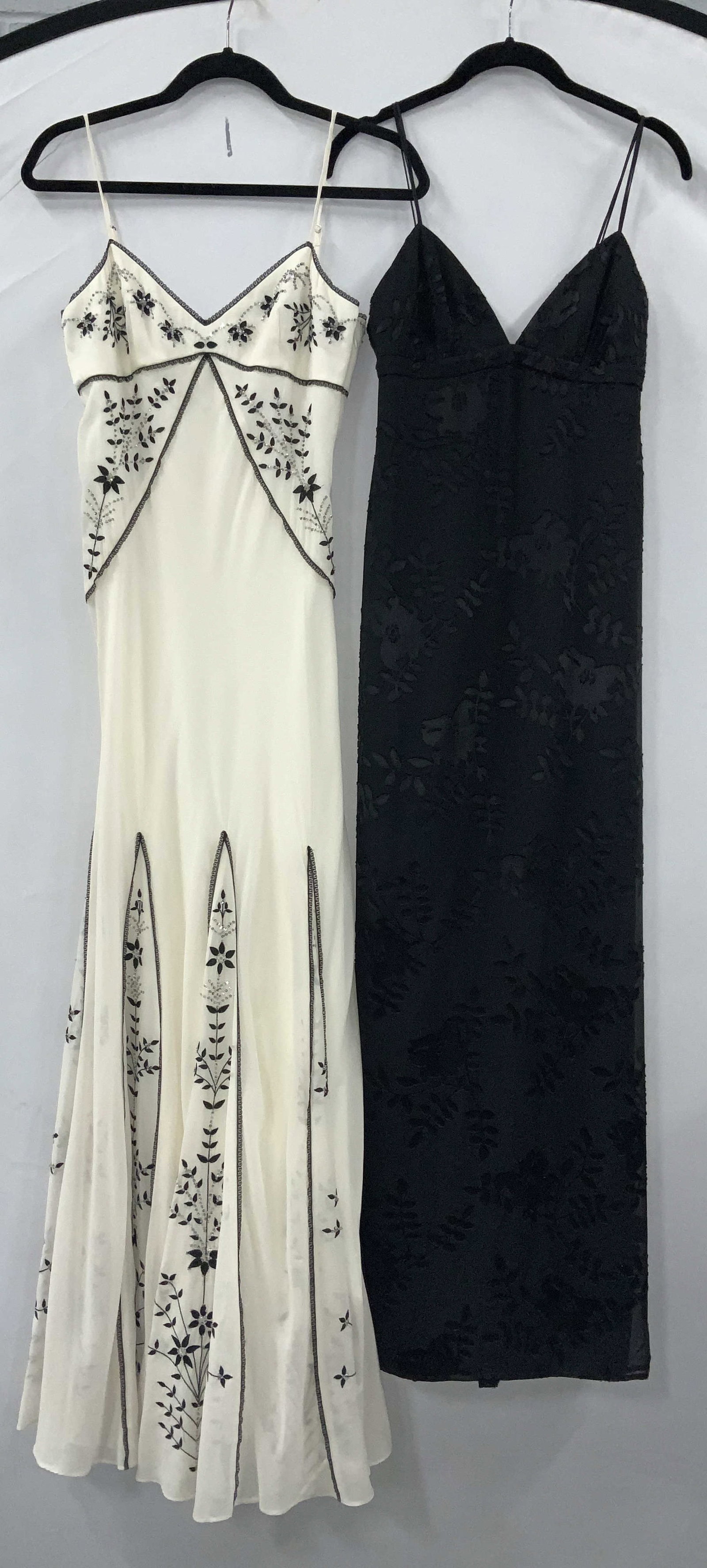 2 BCBG MAXAZRIA Silk Cocktail Gowns: BCBG MAXAZRIA collection spaghetti strap gowns. Both size 2. Black dress is 72% silk with rayon, 57.5 in. L. Cream colored dress with black flower embroidery is 100% silk with a polyester lining, 59.5