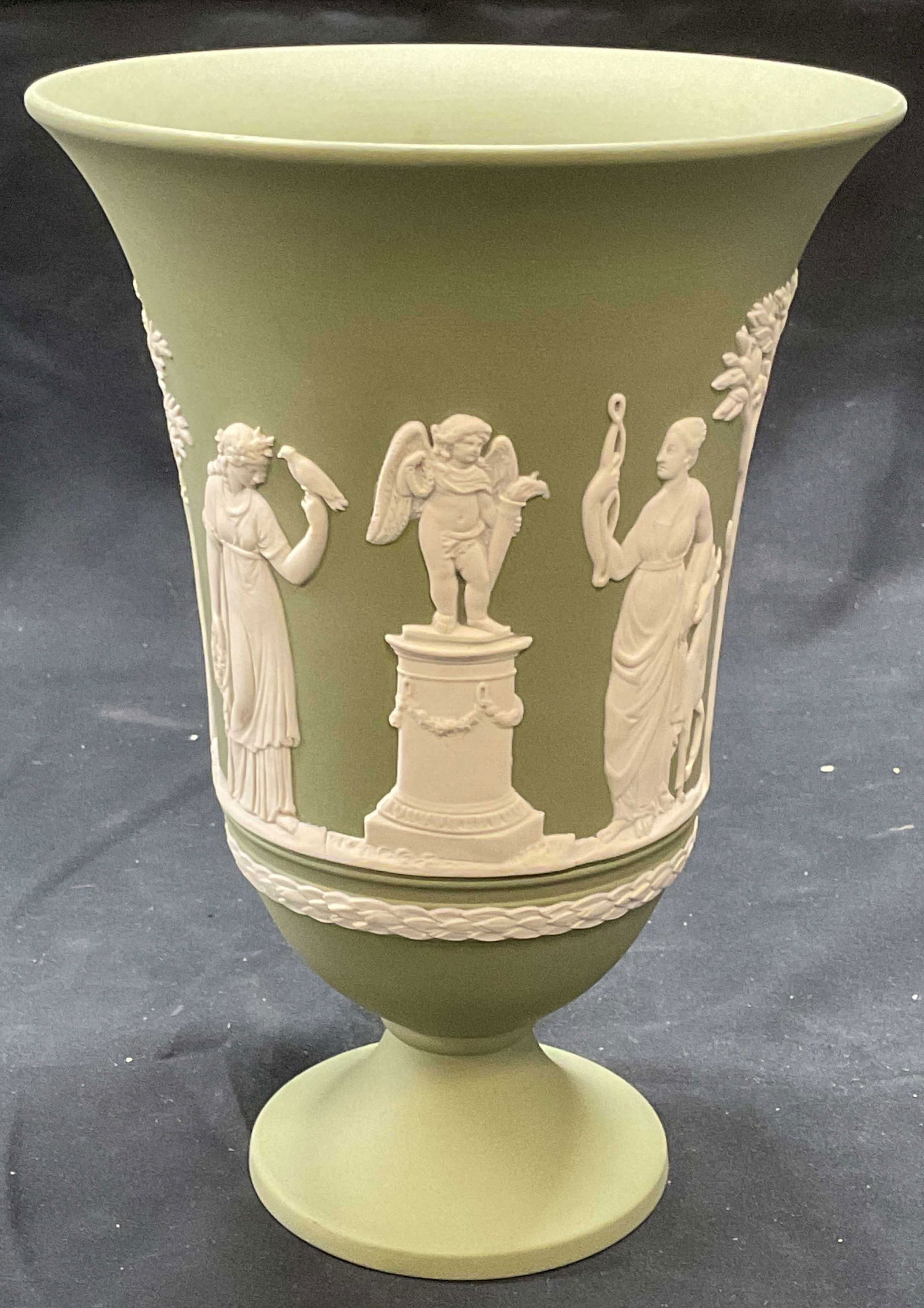 Vntg Wedgwood Green Jasperware Grecian Vase: Vintage Wedgwood green Jasperware vase with fluted rim and footed base. White bas relief with Grecian figural motif. Trademarked to underside. Made in England. Measures approx. 5 x 7.5 inches. Some su