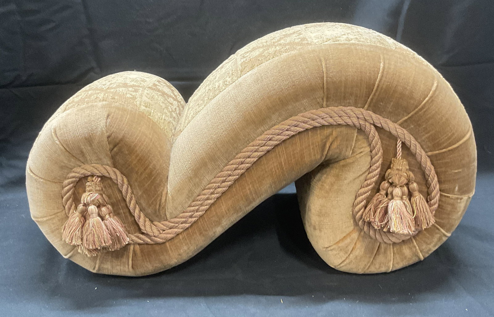 Tan Velvet Upholstered Damask Footstool: Tan velvet damask upholstered footstool. Decorative cable trim and tassel. Damask scroll pattern. Measures approx. 19.5 x 9 x 11 inches. Some wear to material consistent with exposure. Footstool, tan 
