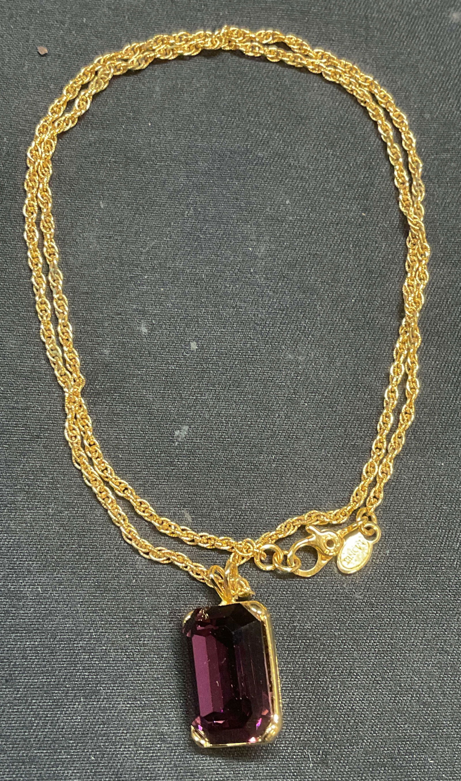 Vintage Monet Gold Tn Purple Crystal Necklace: Vintage Monet gold tone chain necklace with purple crystal pendant. Drop length approx. 8.75 inches. Pendant measures approx. .75 inches long. Signed on hang tag and pendant. Property of P. T. Barnum