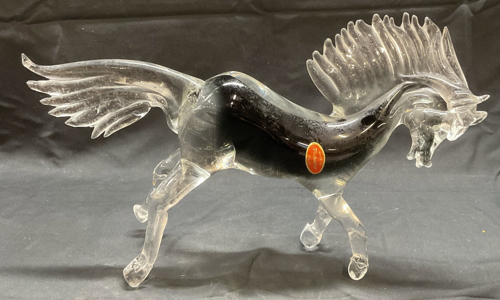 Vintage Murano Art Glass Horse Figural, Italy: Vintage Murano Art glass horse figural. Clear to black. Galloping motif. Signed on sticker. Made in Italy. Piece has weight. Measures approx. 13.5 x 4 x 8.25 inches. Some surface wear including scratc