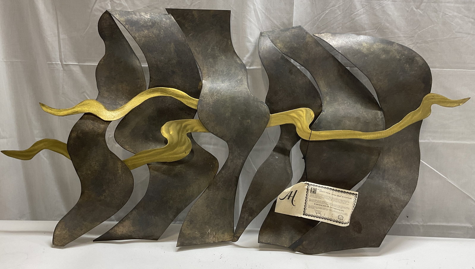 Artisan House Curtis Jere Rippling Metal Sculpture 4ft: Artisan House Curtis Jere metal wall hanging sculpture. Titled Rippling. Silver and gold tone metal with abstract wave motif. Measures approx. 46 x 24 inches. Includes certificate of authenticity. No 