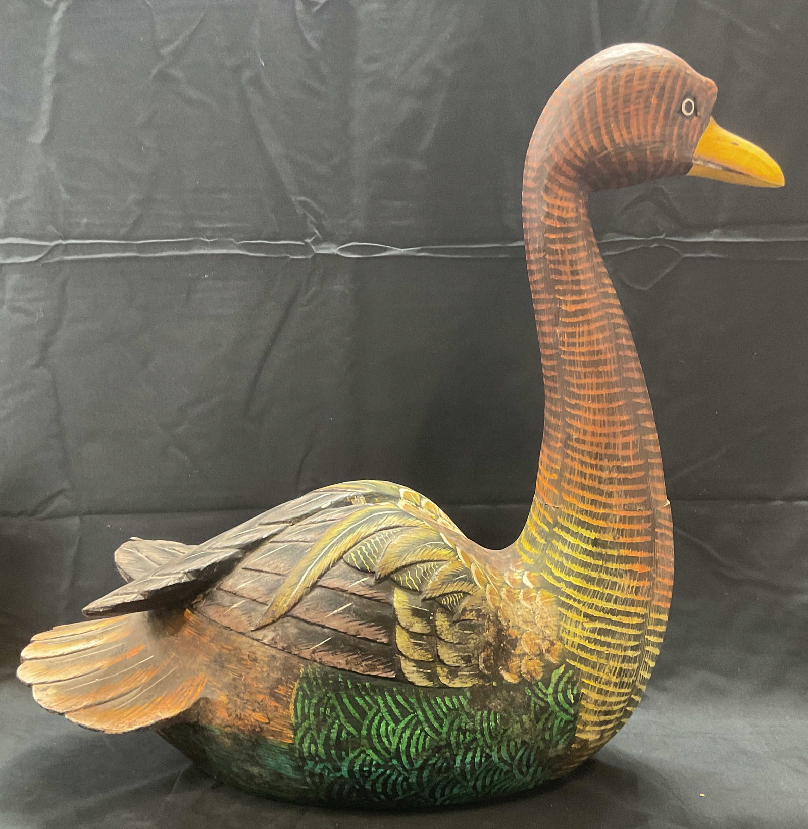 XL Hand Painted & Carved Wooden Duck Sculpture: Hand painted and hand carved wooden duck motif sculpture. Hues of orange, yellow, and green. Measures approx. 20 x 8 x 20.5 inches. Piece has weight. Surface wear including splitting on one side, scra