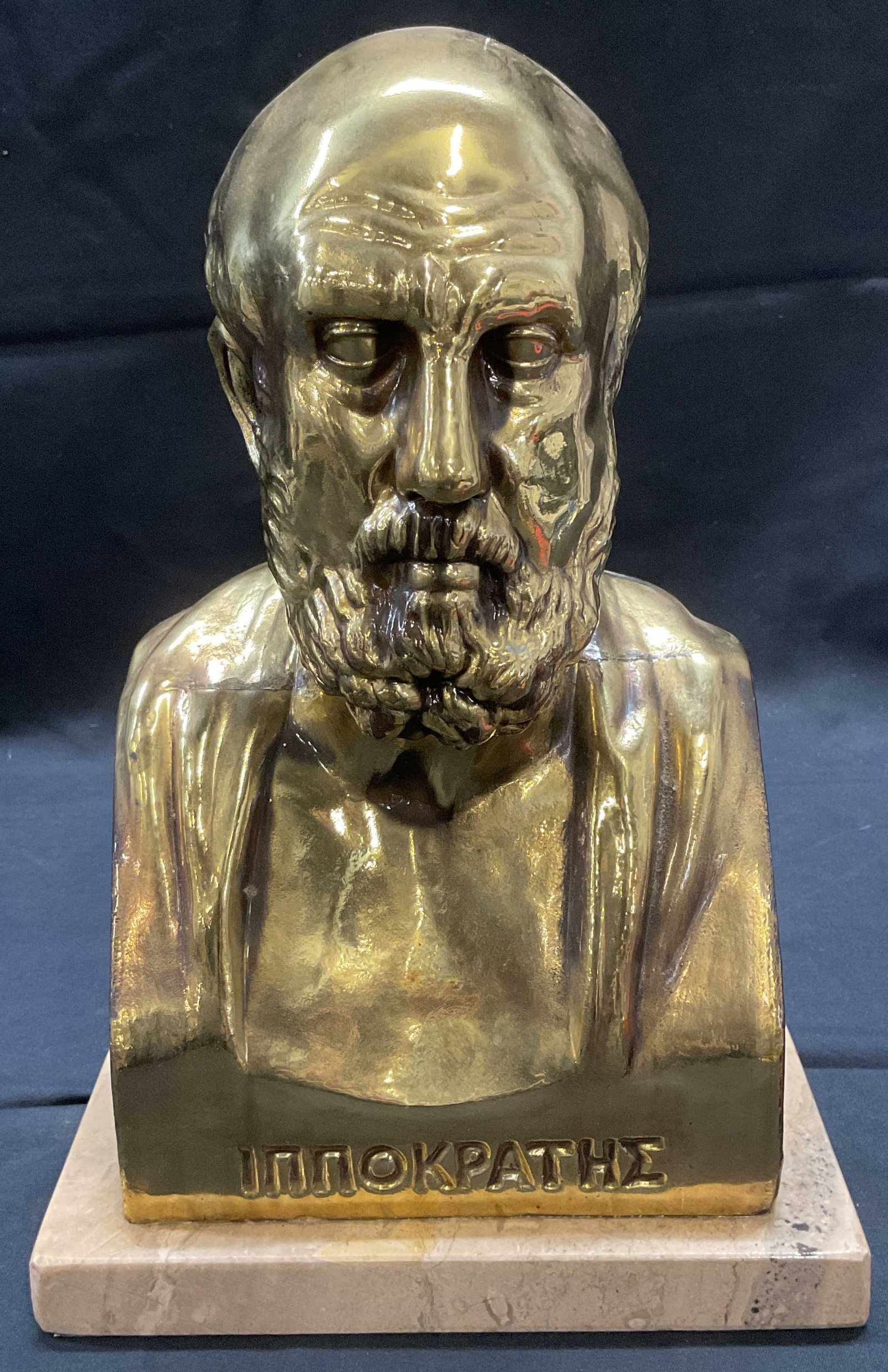 Signed Cast Brass Bust of Hippocrates, Greece: Vintage cast brass bust of Hippocrates. Inscribed in Greek. Faux marble base. Signed on reverse. Made in Greece. Measures approx. 7 x 4 x 10.5 inches. Some surface wear including scratching observed. 