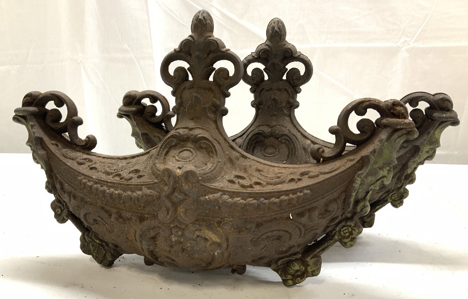 Pair Antique Cast Iron Venetian Ornaments, 15in. L: Pair of ornately embossed cast iron ornaments. Appear to have originated in Venice with a distinct gondola shape that has scrolling and a Fleur de lis tip. Ends have the face of Bacchus or other god. 