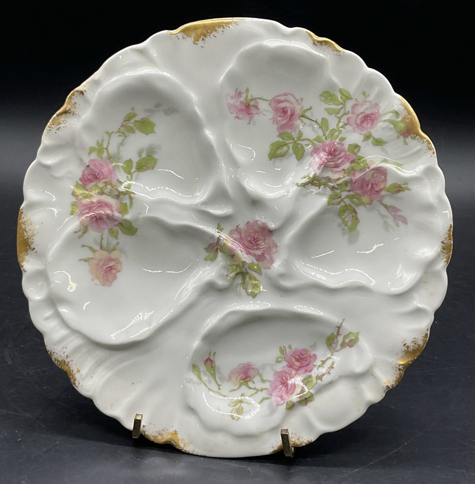 HAVILAND LIMOGES French Porcelain Oyster Plate: A vintage hand painted floral motif porcelain oyster plate. Gilt accents to the piece. Reverse signed HAVILAND LIMOGES CH FIELD, FRANCE. Measures approx. 7.75W x 7.75L in. Surface wear consistent with