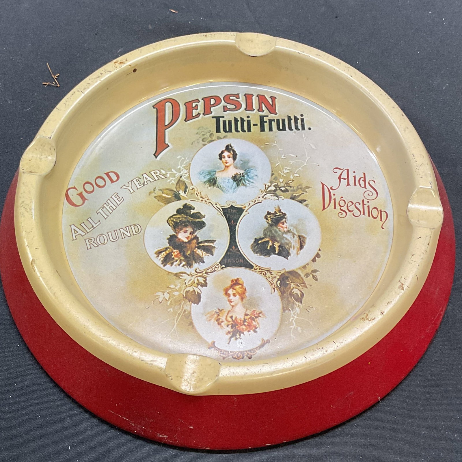 Case Mfg Co Antique Style Pepsin Metal Ashtray: Case Manufacturing Co antique style advertisement ashtray. Pepsin Tutti Frutti with figural motif. Enamel over metal. Signed in underside. Made in England. Measures approx. 8 x 1.25 inches. Some surfa