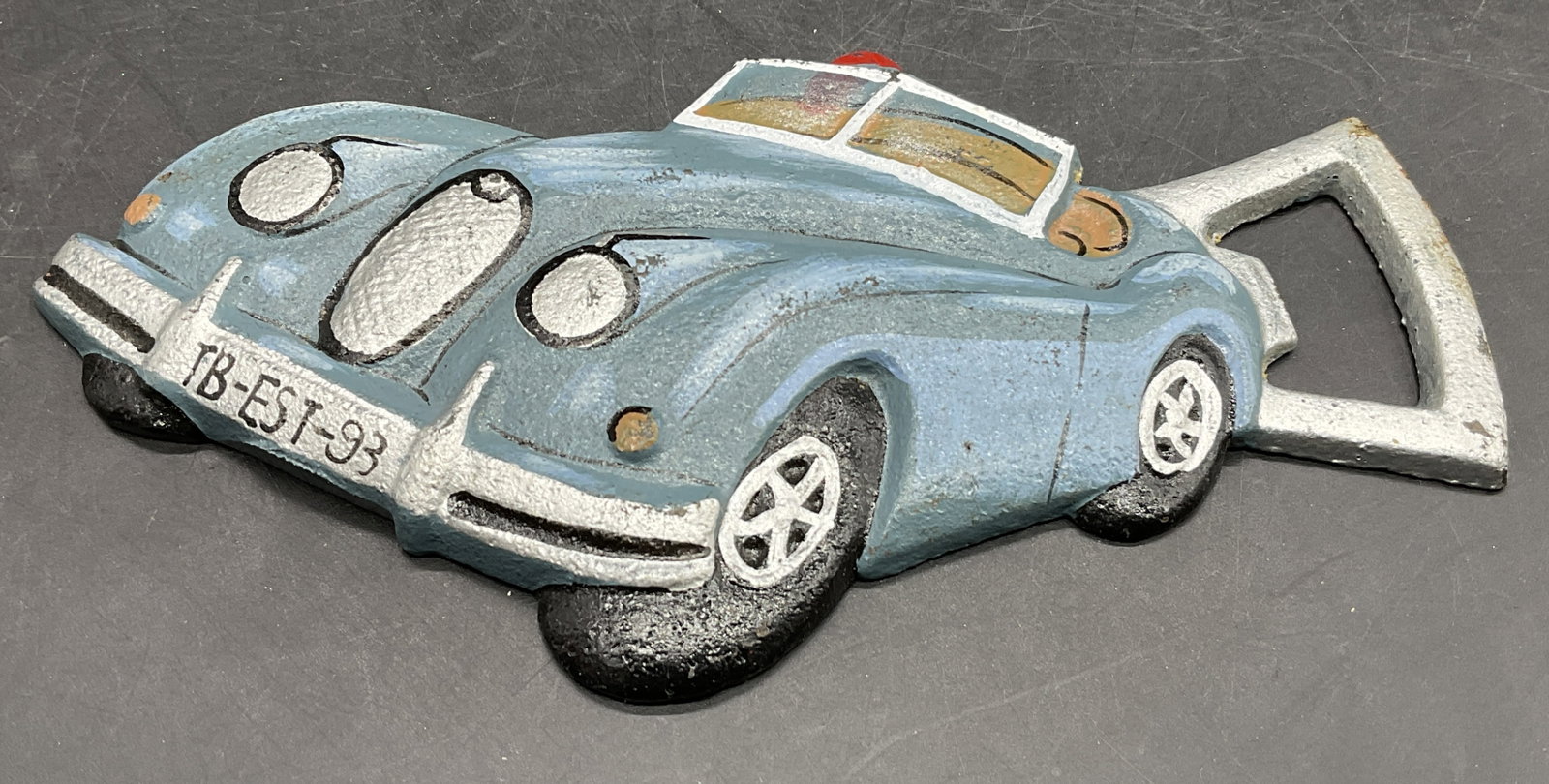 Cast Iron European Race Car Bottle Opener: A painted cast iron European race car bottle opener. Measures approx. 5.25W x 2.75L in. Some wear consistent with age, use, and exposure. Wear to paint present. home decor, home accents, homewares, ho
