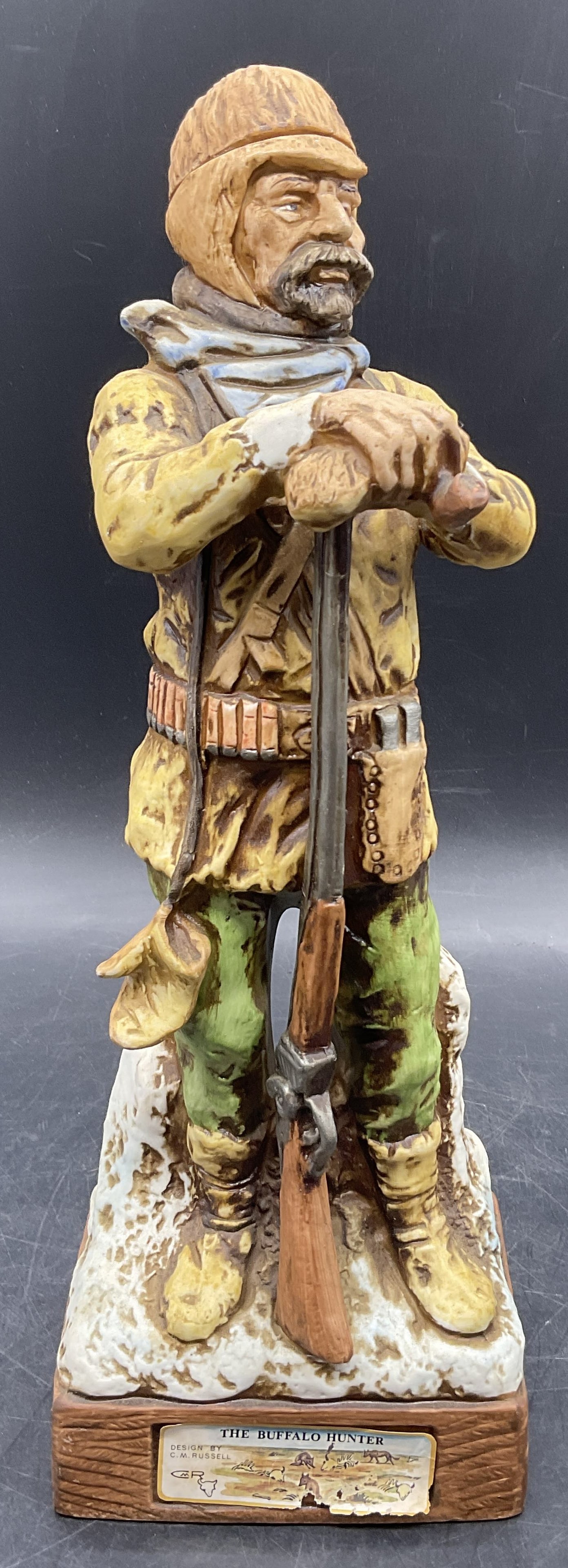 HOFFMAN 1976 The Buffalo Hunter Ceramic Decanter: Vintage Hoffman Decanter The Buffalo Hunter By C M Russell 1976. Sticker to obverse and signature to the underside. The hat is the lid to the piece. Measures approx. 12.5H x 4.5W in. Some surface wear