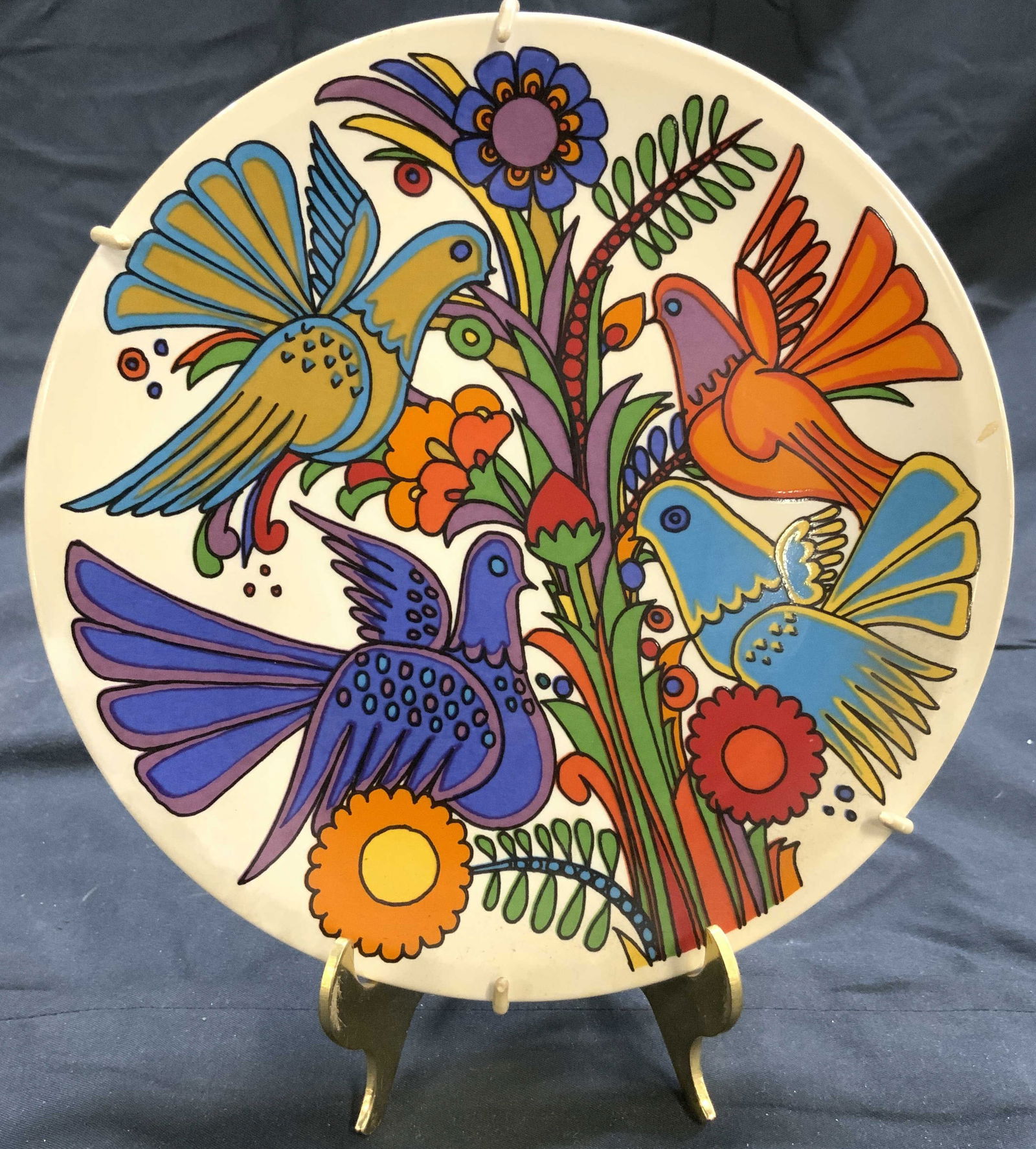 VILLEROY & BOCH Porc Plate W Bird & Floral Detail: Underside reads VILLEROY & BOCH ACAPULCO MADE IN LUXEMBOURG. Plate is cream toned and porcelain. Piece has multi toned floral, leaf & bird detail. Plate is in metal holder. Piece measures approximatel