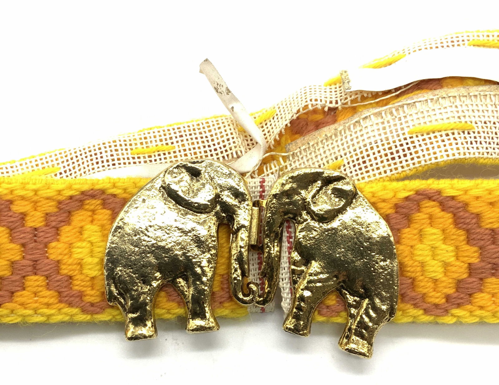 Handmade Woven Wool Belt w Elephant Buckle: Handmade belt with colorful and bright wool yarn on canvas. Geometrical pattern. Colors of bright saffron, orange and rusty brown. Belt buckles are gilt metal elephant Figurals, measure approx 2.5 in.
