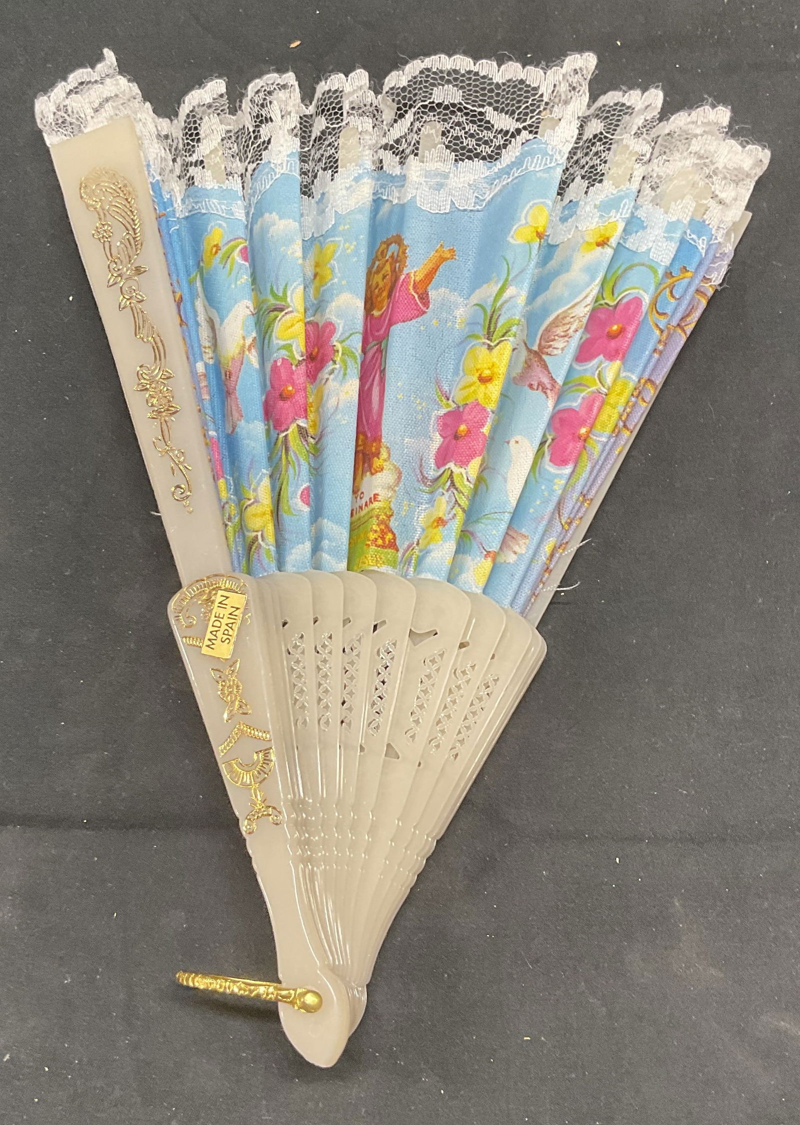 Vintage Christ Child Folding Fan, Spain: Vintage fabric and acrylic folding fan with printed image of the Christ Child and floral motif. Measures approx. 9 inches long. Includes box. Made in Spain. Some wear to material and separation of fab