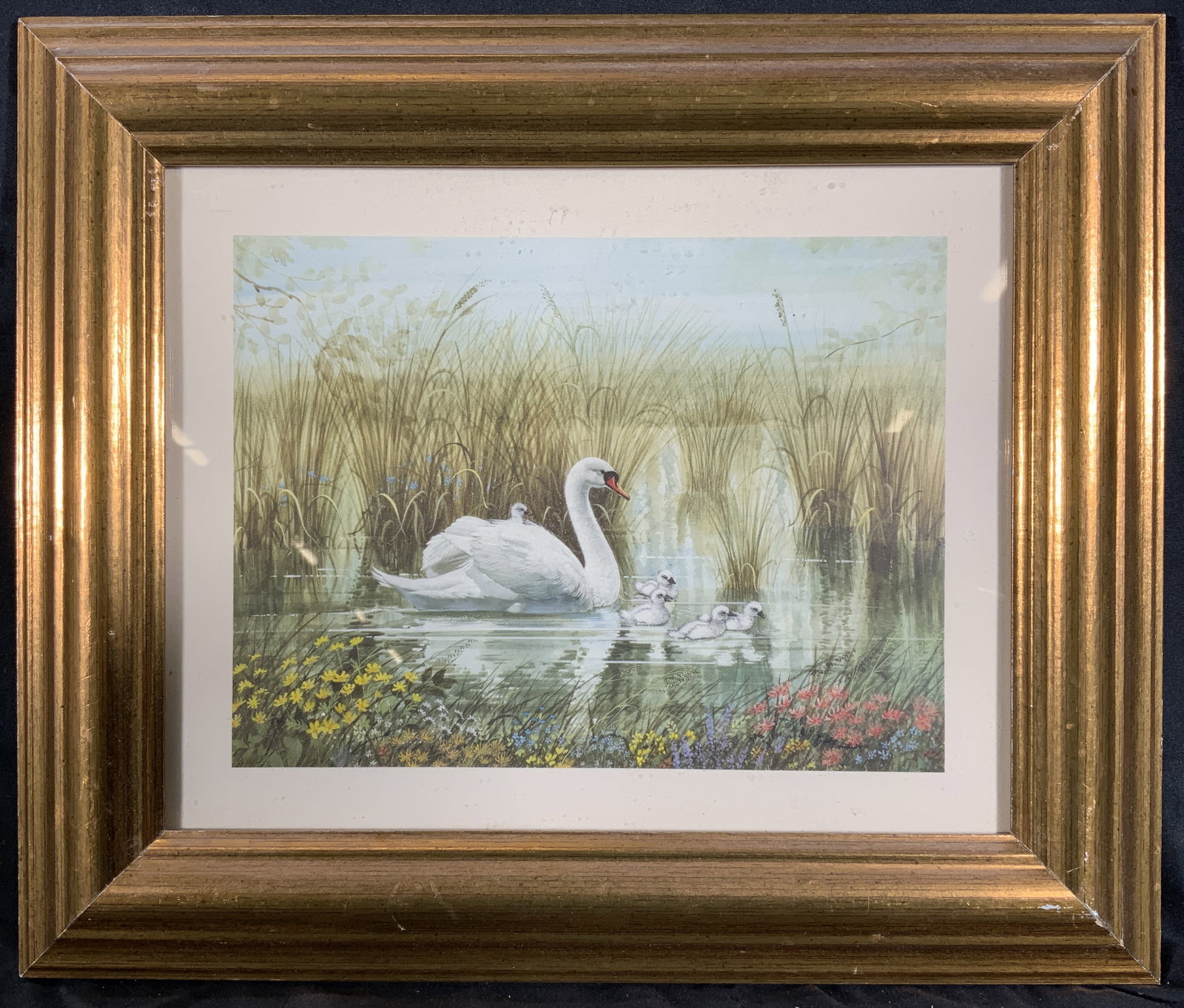 Framed Swan & Babies in the Pond Lithograph: Lithograph on paper. Subject depicts a swan with her babies in a pond with flowers growing in the grass. Framed in a gilt wooden frame. Frame measures approx. 13W x 11 H in. Window measures approx. 9.
