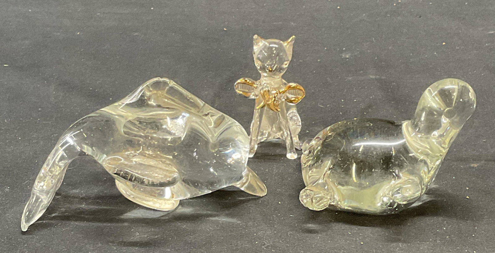 Lot 3 Art Glass Dolphin, Turtle, Cat Figurals: Lot of 3 Art glass animal Figurals. Turtle, Dolphin, and cat motif, cat has gilt decoration. Largest measures approx. 4 x 2.5 x 2.5 inches. All pieces have some surface wear including scratching obser
