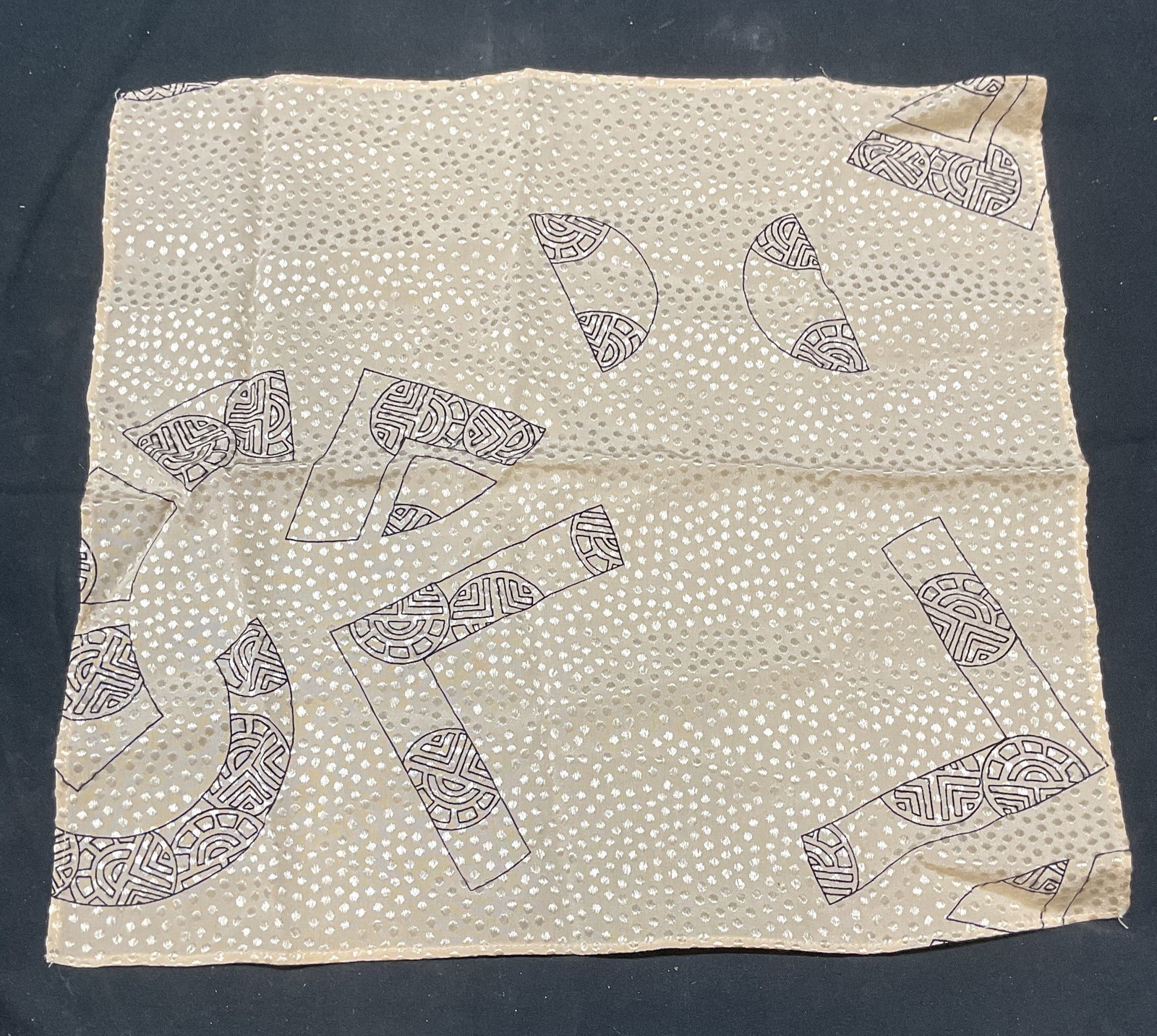 Beige Graphic Print Handkerchief: Beige and black graphic print handkerchief. Measures approx. 12 x 11.25 inches. Material feels synthetic. Some wear to material consistent with exposure. Handkerchief, beige handkerchief, graphic prin