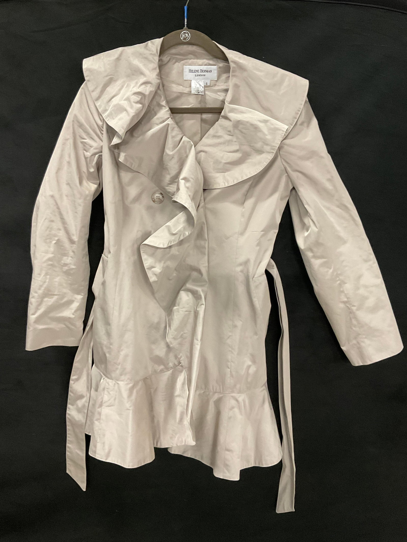 HELENE BERMAN LONDON Tie Waist Jacket: A Helene Berman jacket. Tie closure. Four buttons to the exterior. Tag reads HELENE BERMAN LONDON. Size tag reads S. Material tag lists manmade synthetics for the composition of the piece. Length meas