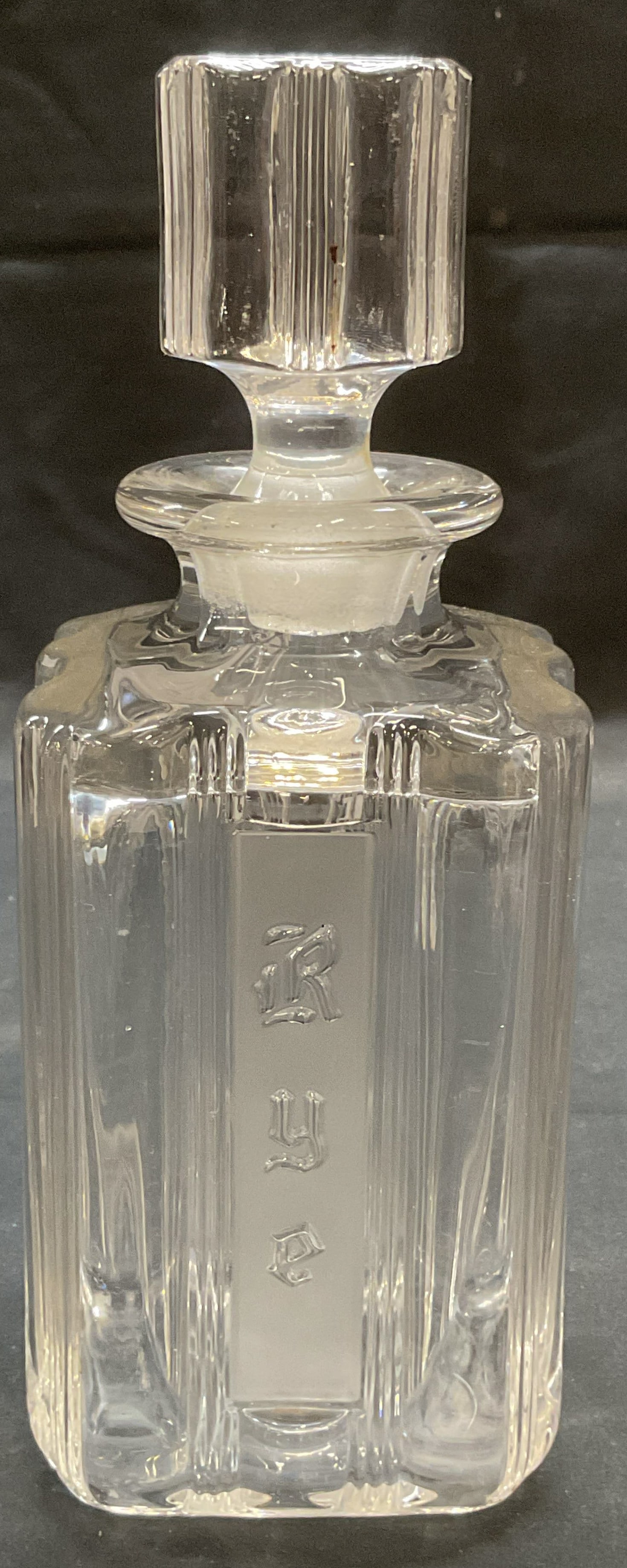 Heavy Glass Rye Whiskey Decanter: Heavy glass Rye whiskey decanter with scalloped body. Thick walled glass. Reads Rye on exterior. Measures approx. 3.5 x 3.5 x 9 inches. Some surface wear including scratching observed. Some chipping o