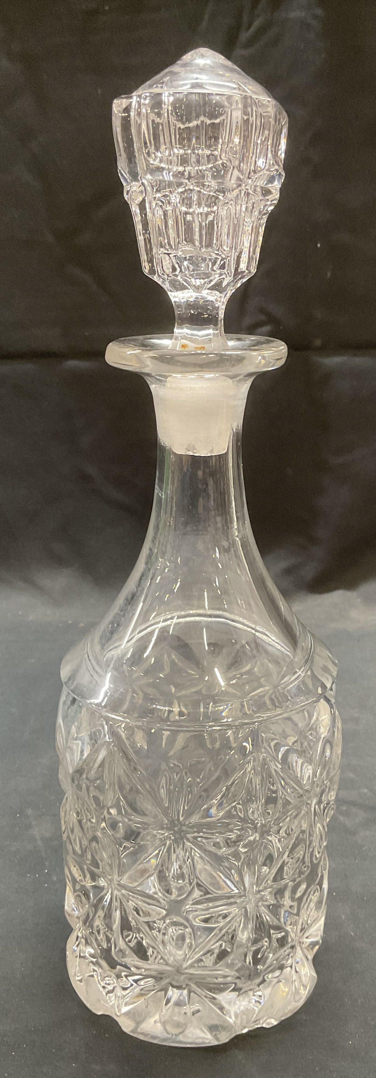 Heavy Crystal Starburst Decanter: Heavy crystal decanter with geometric starburst motif. Thick walled crystal. Measures approx. 3.75 x 12 inches. Some surface wear including scratching observed. Decanter, crystal decanter, starburst d