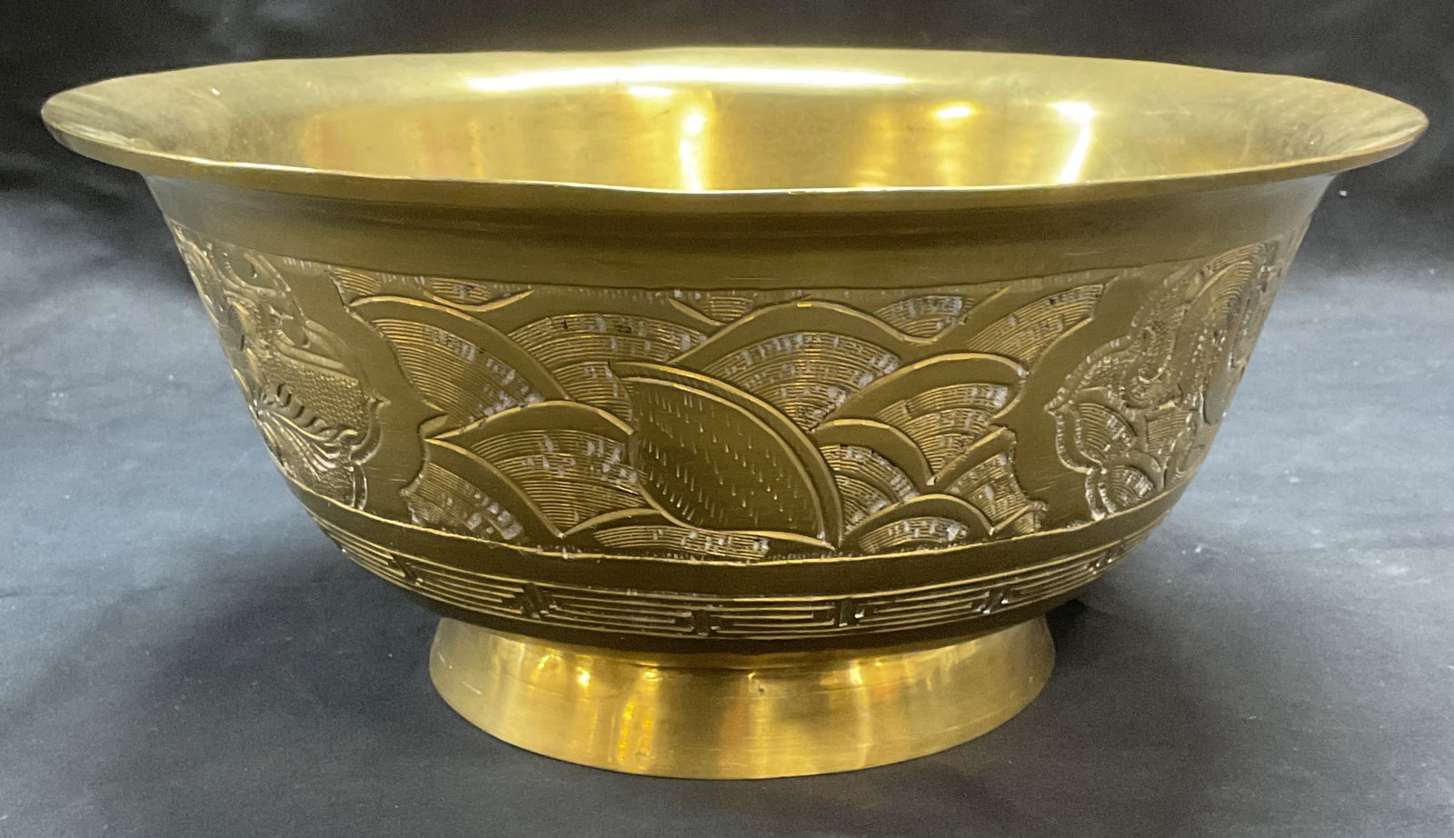Signed Chinese Heavy Chased Brass Bowl: Signed Chinese brass bowl. Chased dragon motif. Signed on underside. Piece is heavy. Measures approx. 10.25 x 4.75 inches. Some surface wear including scratching and warping observed. Brass bowl, drag