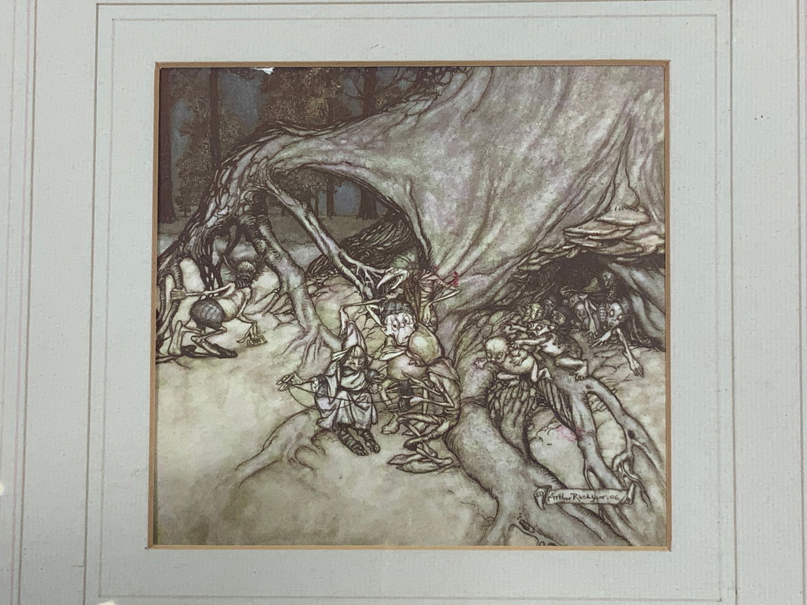 After Arthur Rackham Peter Pan Bad Fairies Litho: Lithograph on paper. Art after Arthur Rackham for the novel Peter Pan in Kensington Gardens. Subject depicts the bad fairies running in and out of a tree trunk sitting and talking. Framed in a gilt wo