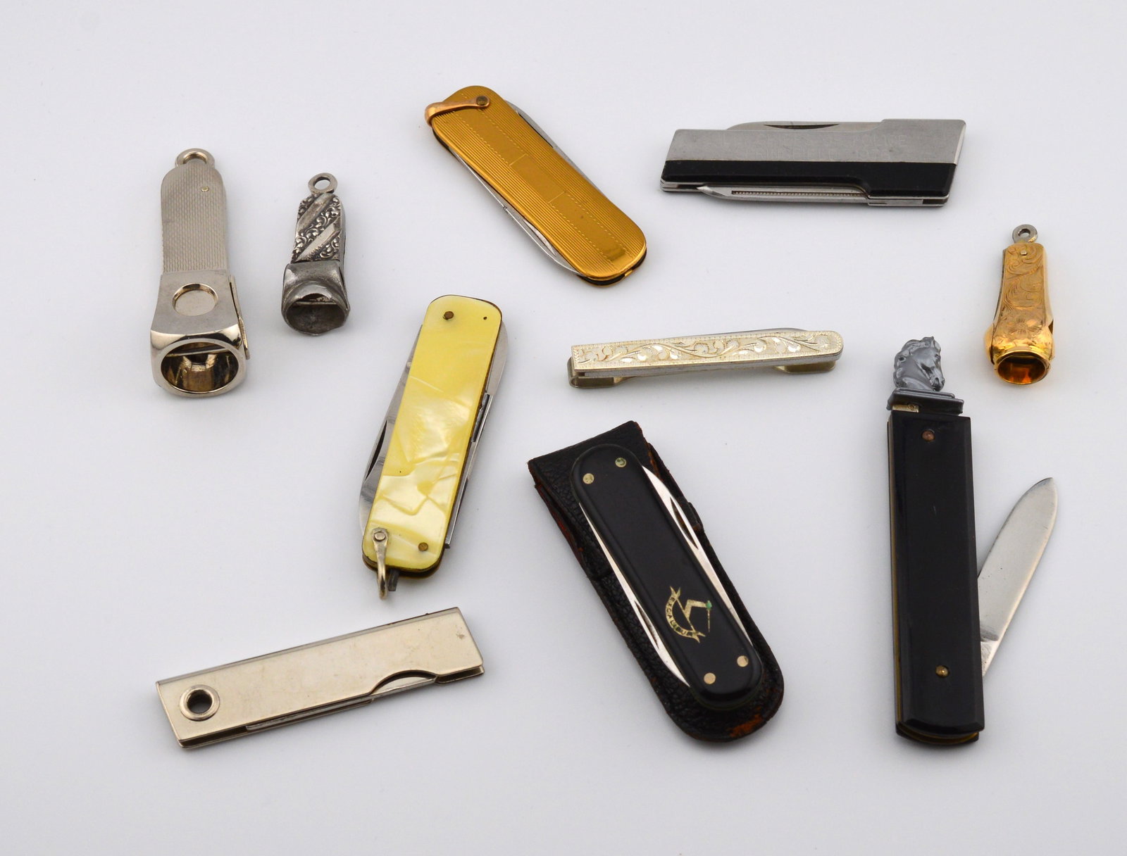 Lot Vntg Pen Knives, Tie Clips, Cigar Cutters: Collection of Vintage Pen Knives, Tie Clip and Cigar CuttersIncluded are 10 different pen knives ranging in size from 2.5 in to 3.5 in. They are mixed metals and other natural materials. The 3.5 in ho