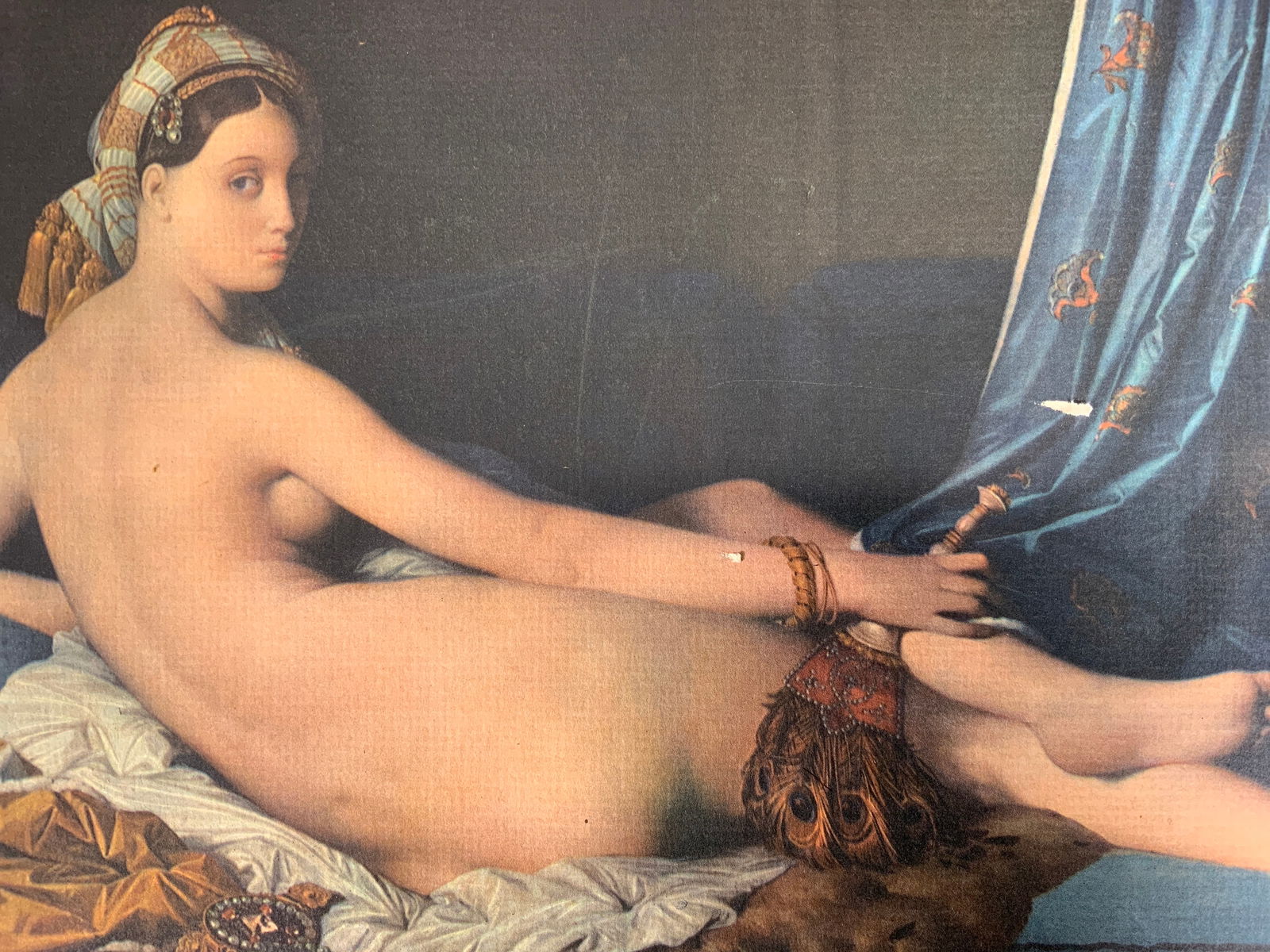 After Jean-Auguste-Dominique Ingres Odalisque: Lithograph on paper. Art after Jean-Auguste-Dominique Ingres. Titled Grande Odalisque Couchee. Subject depicts a nude woman concubine lying in bed with a feathered tool and a pipe. Framed matte coveri