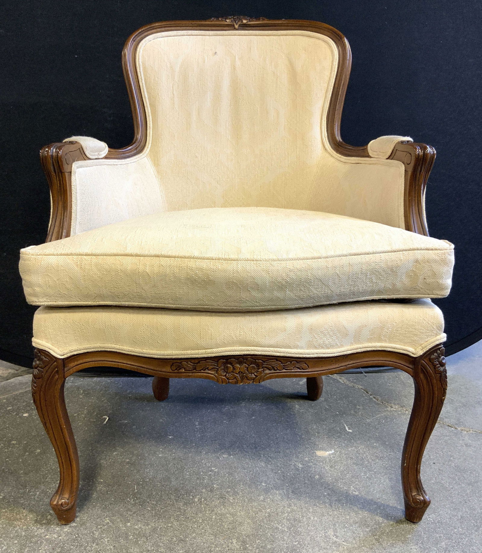 Vntg Louis XV Style Country French Armchair: Country French Louis XV side armchair. Piece has carved wooden frame & cream toned upholstery. Chair appears to be vintage, Frame has carved wooden floral & leaf detail. Armrests have upholstered area