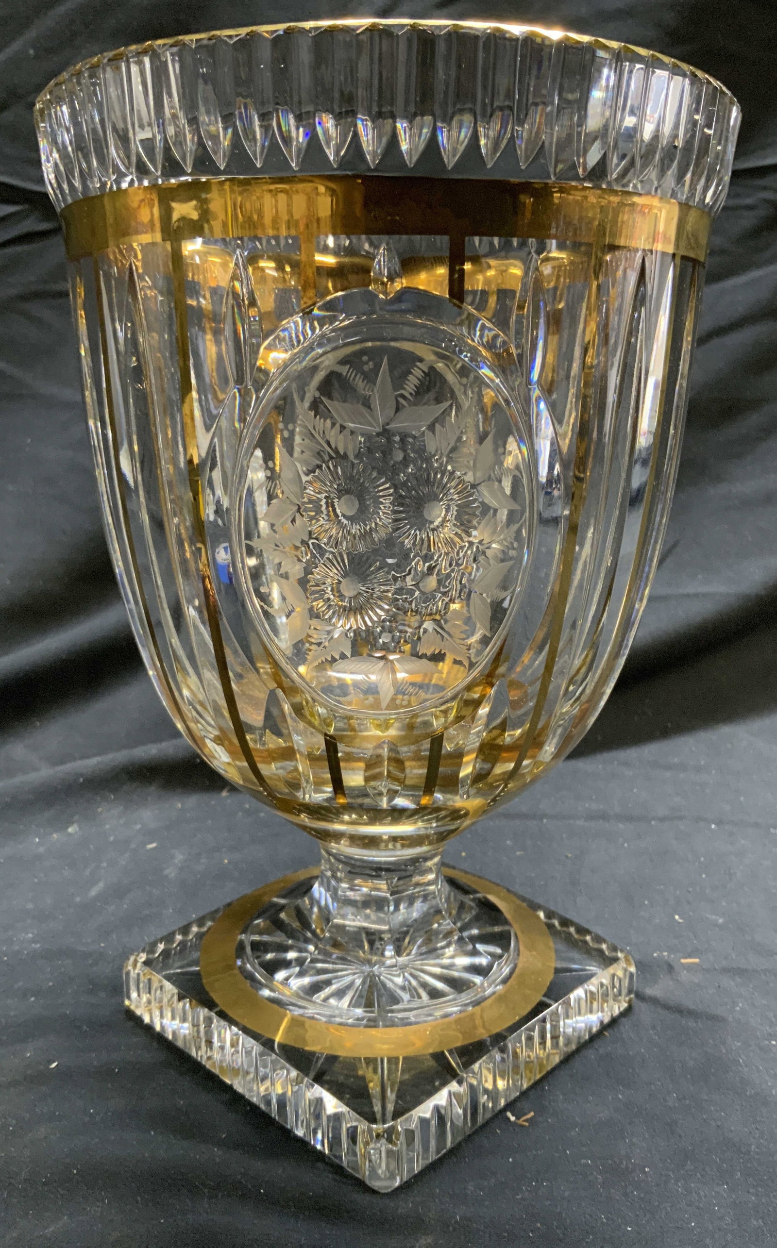 Crystal & Gilt Stemmed Scalloped Vessel: Vessel is crystal. Piece has scalloped exterior. Vessel has areas of gilt detail. Piece has floral & frosted leaf detail. Base of vessel is square shaped. Piece measures approx 8.75 inches tall 6 inch