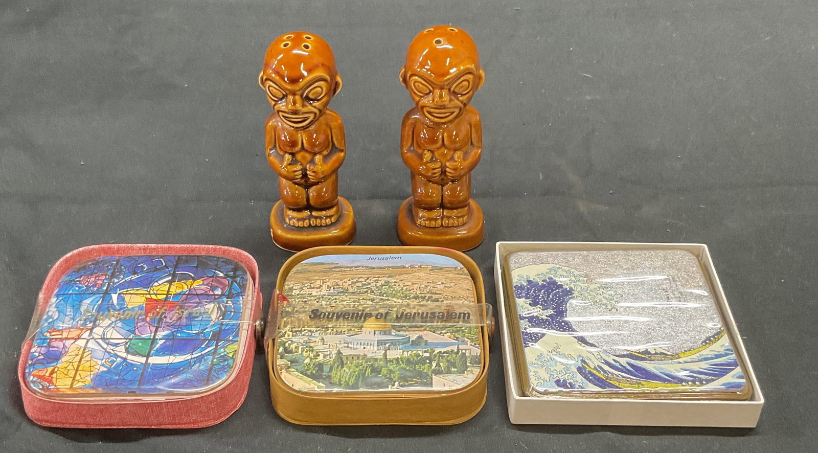 Lot 5 Kon Tiki Shakers, Souvenir Coasters: Lot of 5 pieces. Set of Jerusalem, Israel, and Hokusai souvenir coasters. Measure approx. 3.25 x 3.25 inches. Pair of glazed ceramic Kon Tiki salt and pepper shakers. Measure approx. 1.5 x 4.25 inches