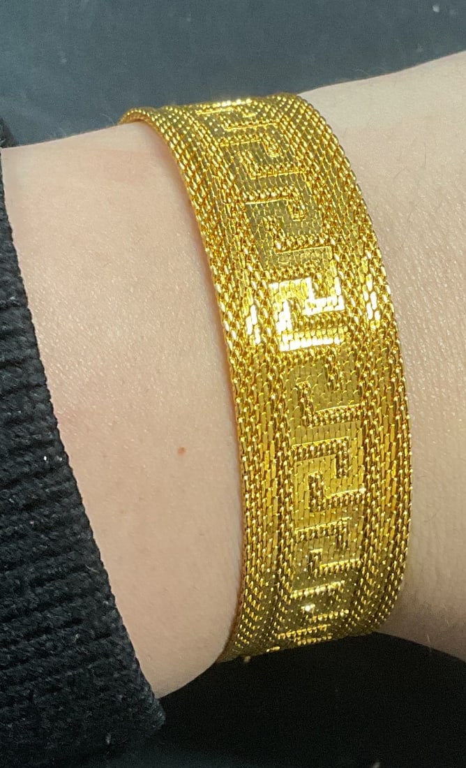 Gold Tone Mesh Chain Greek Key Bracelet: Gold tone mesh chain bracelet with raised Greek key pattern and tassel. Adjustable fit. Measures approx. 7.75 inches wide. Some surface wear including scratching observed. Jewelry, estate jewelry, cos