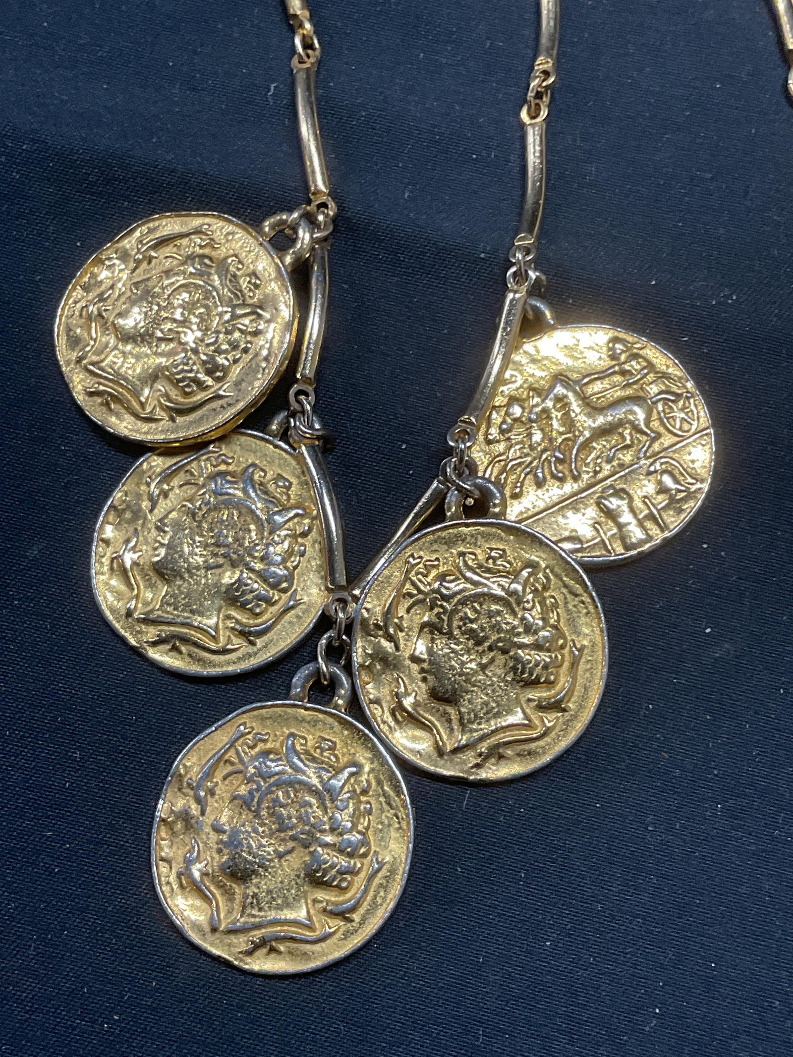 Gold Tone Greek Coin Motif Pendant Necklace: Gold tone necklace with Greek coin motif pendants. Drop length approx. 19 inches. Some surface wear including scratching observed. Jewelry, estate jewelry, costume jewelry, cocktail jewelry, fashion j
